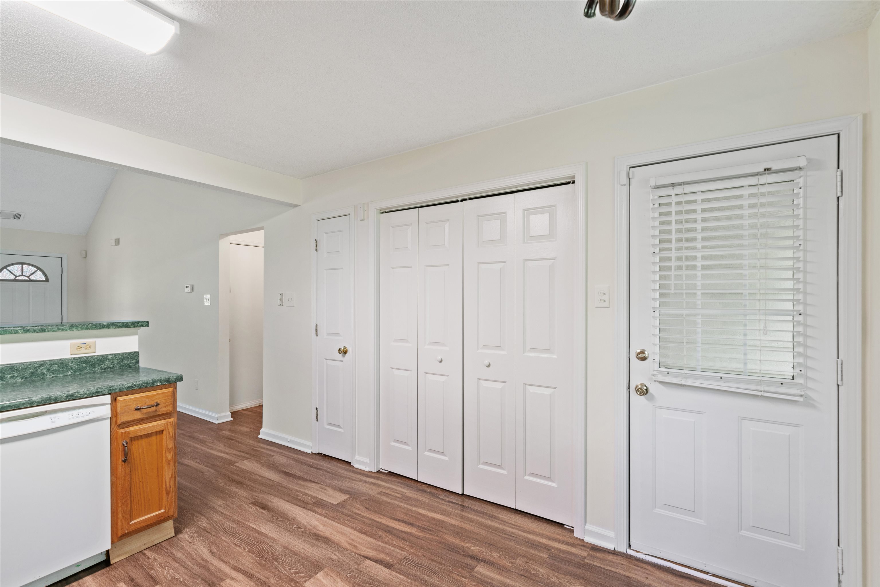 Kitchen featuring lofted ceiling, dishwasher, and wood-type flooring