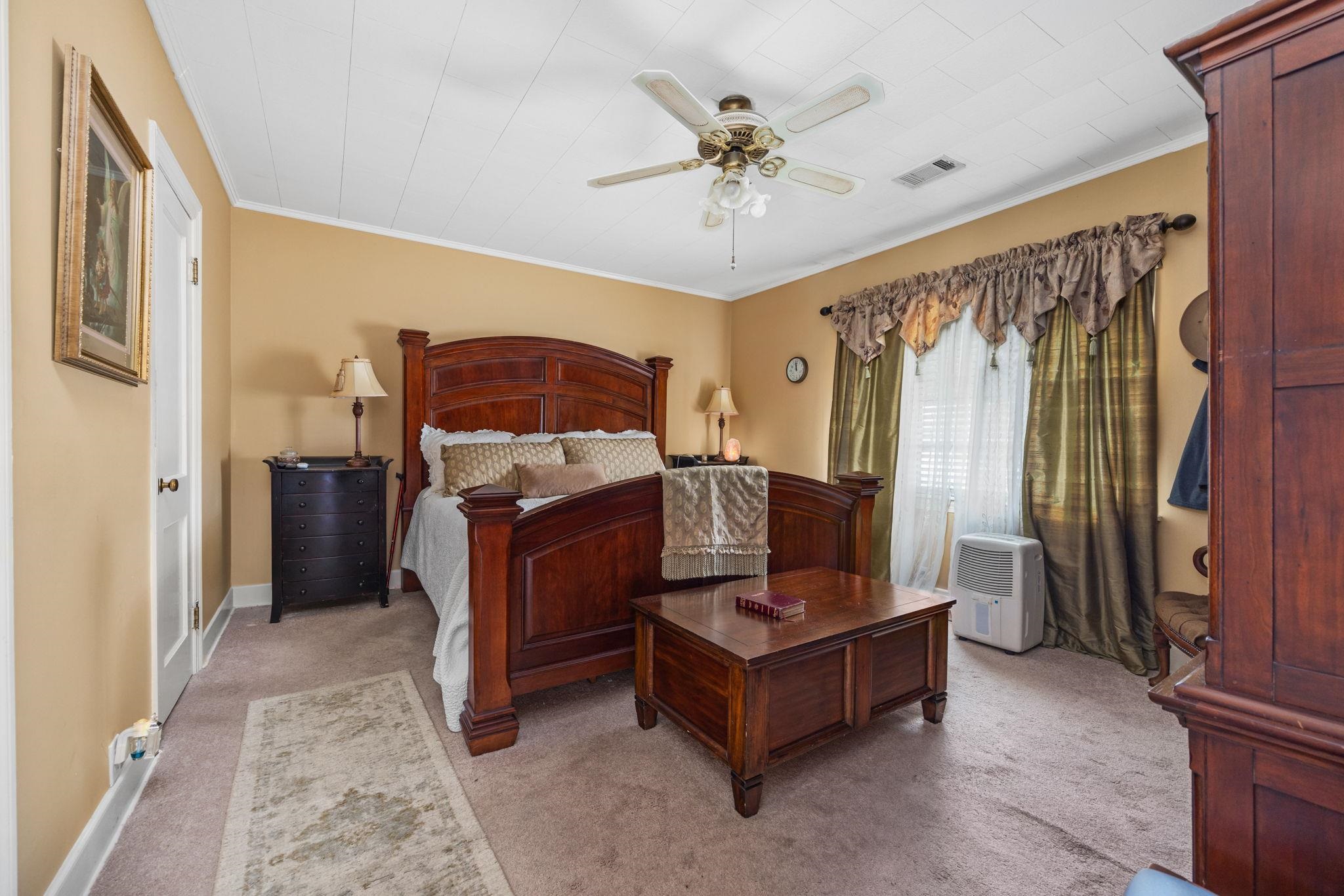 Bedroom with carpet flooring, ceiling fan, and crown molding