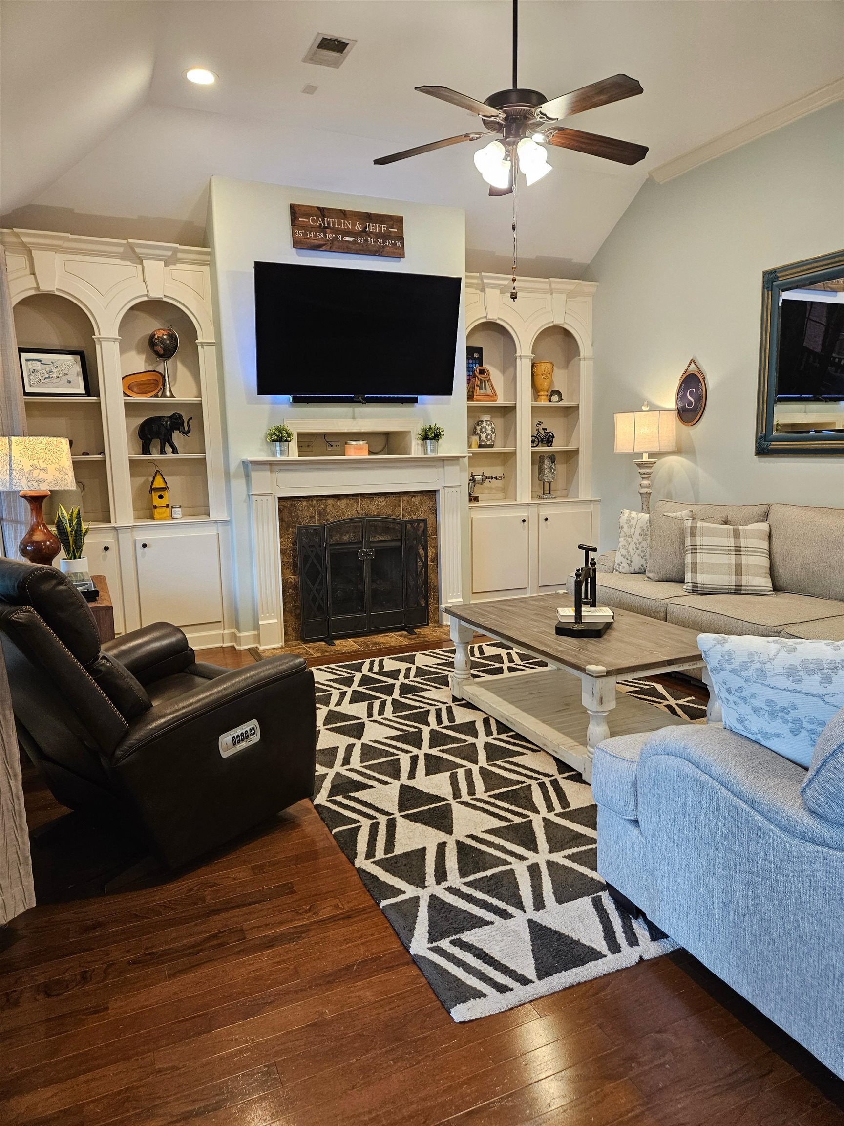 The Great Room features a lofted ceiling, hardwood flooring, ventless gas fireplace with tile surround and mantle, elegant built-in shelving, ceiling fan and entrance to the screened back porch.