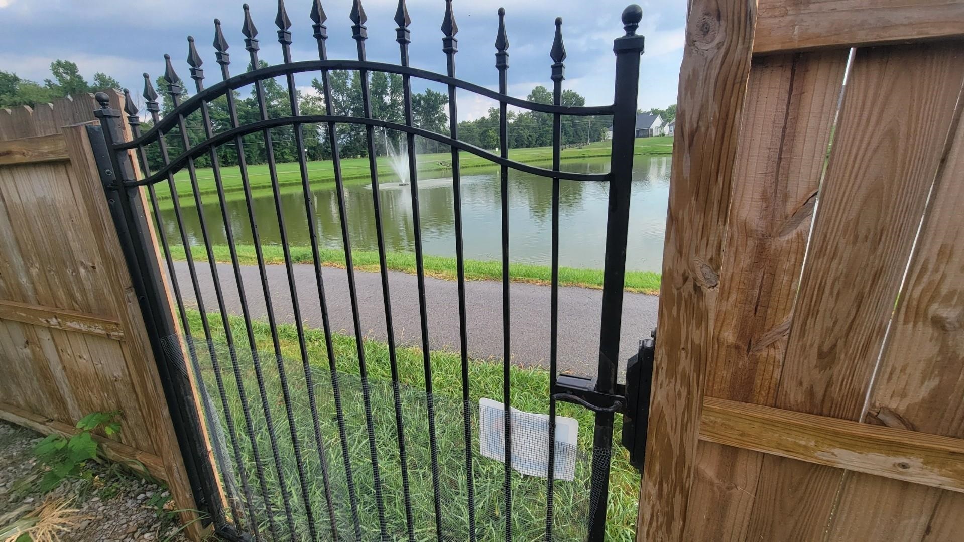 View of gate with a water view and a yard