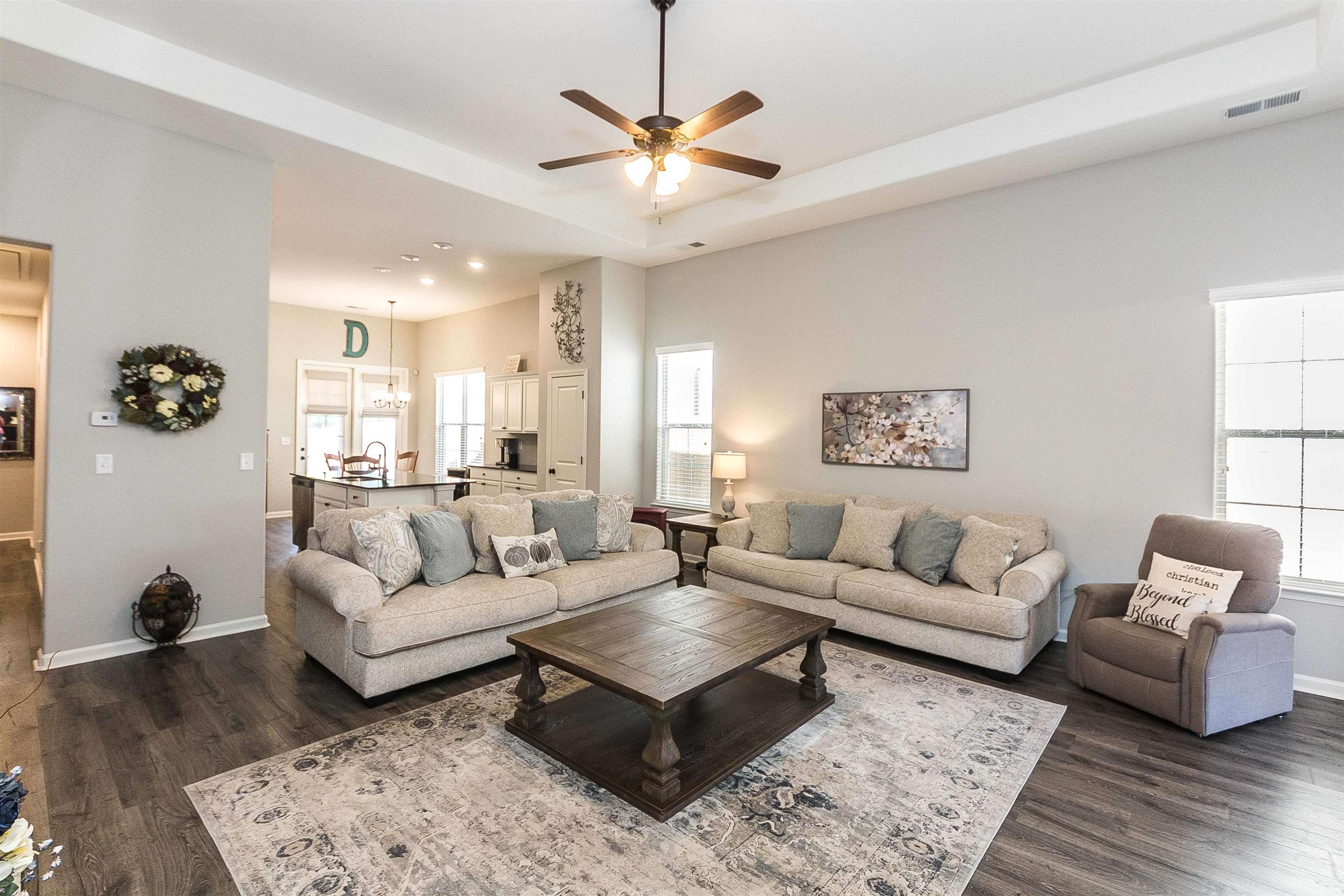 Living room featuring sink, ceiling fan, dark hardwood / wood-style floors, and a towering ceiling