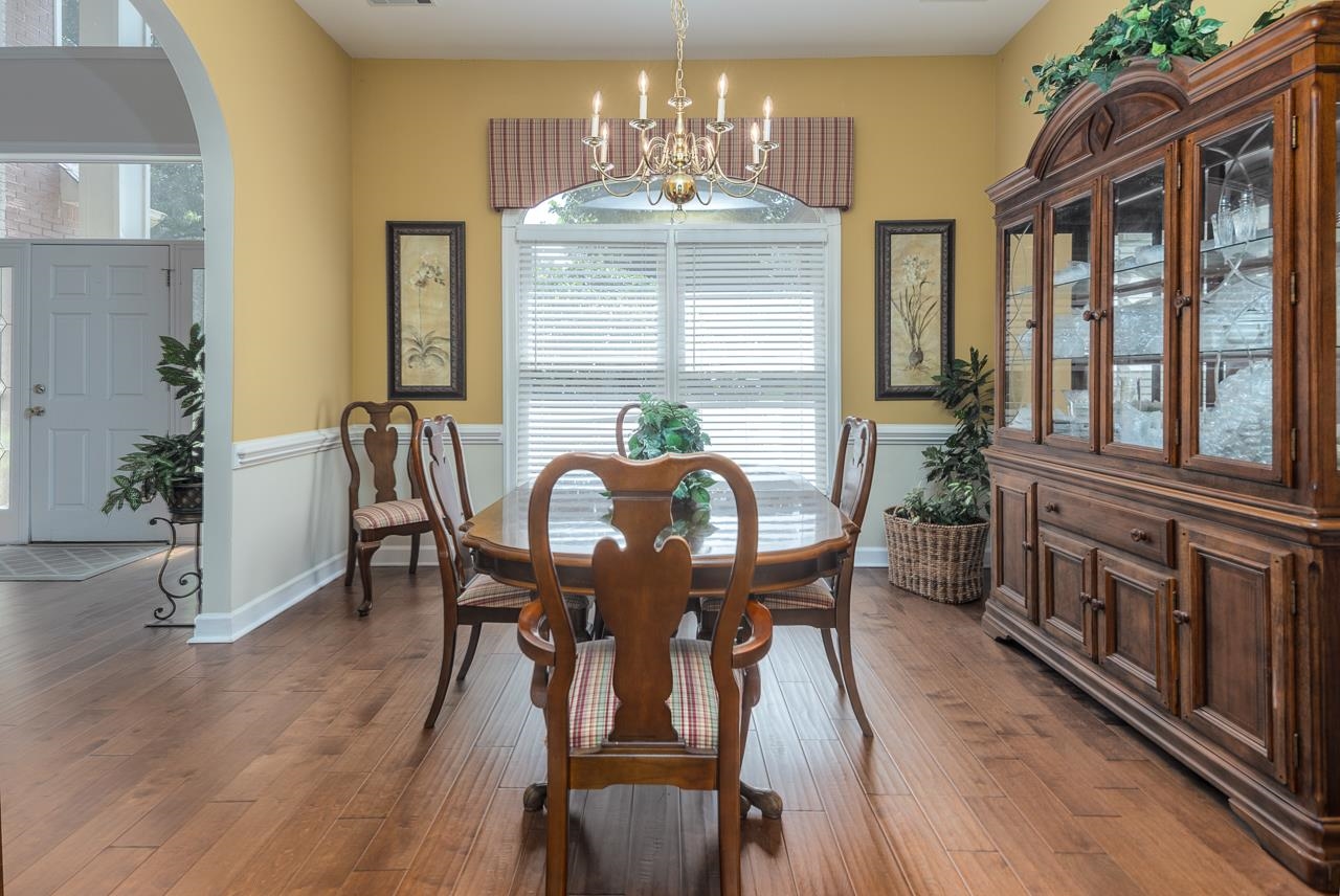 Dining area featuring hardwood / wood-style flooring, a healthy amount of sunlight, and a notable chandelier