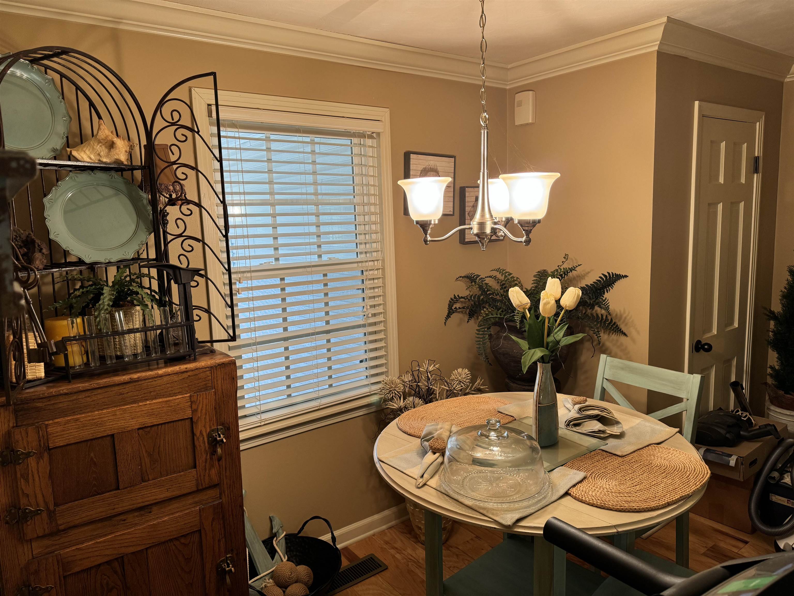 Dining room with crown molding, a chandelier, and hardwood / wood-style flooring