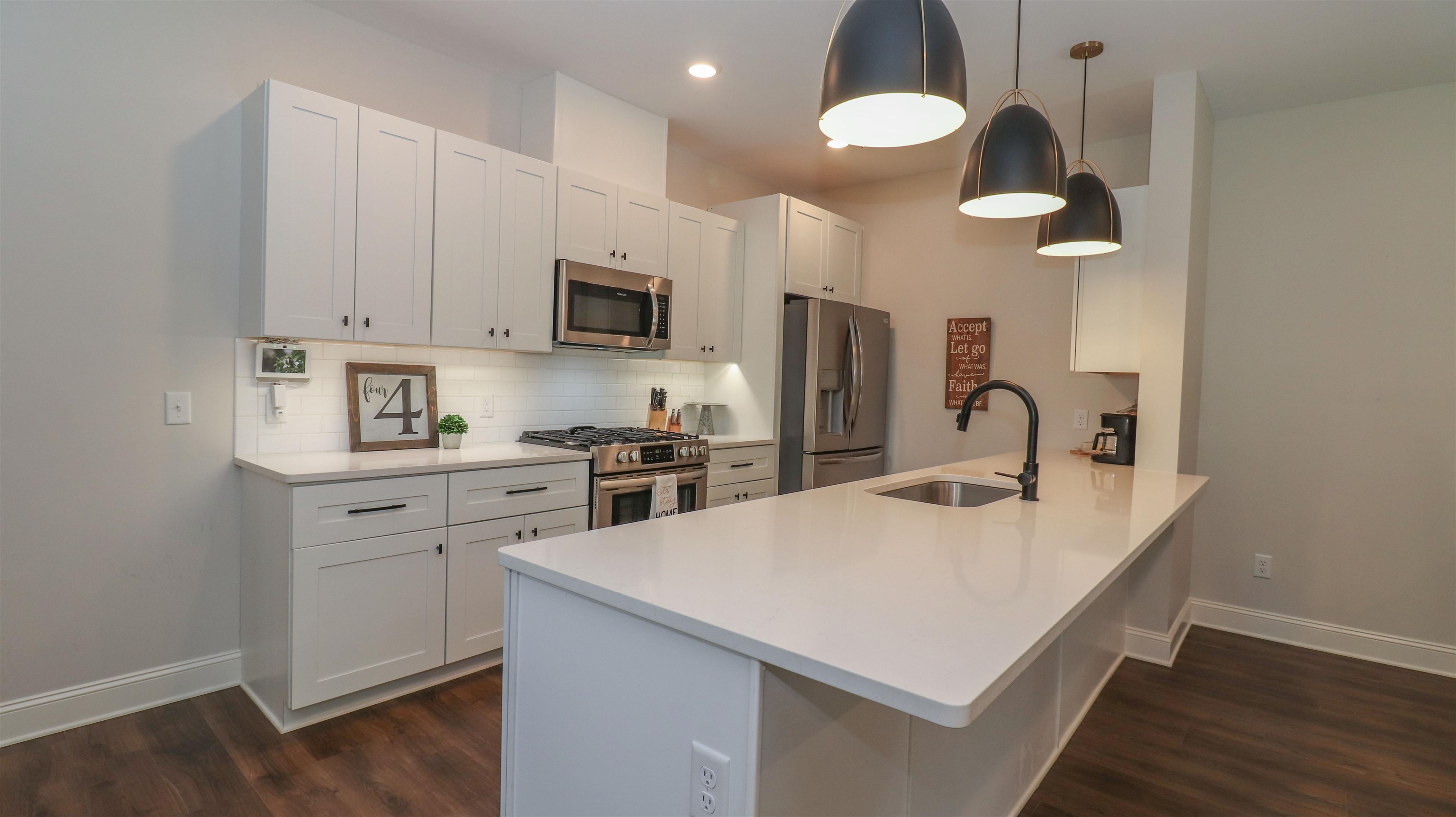 Kitchen with sink, appliances with stainless steel finishes, dark hardwood / wood-style flooring, and backsplash