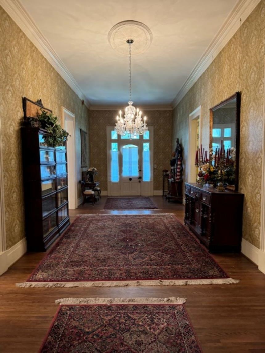 Expansive 12x36 entry foyer with a notable chandelier, crown molding, and hardwood / wood-style floors