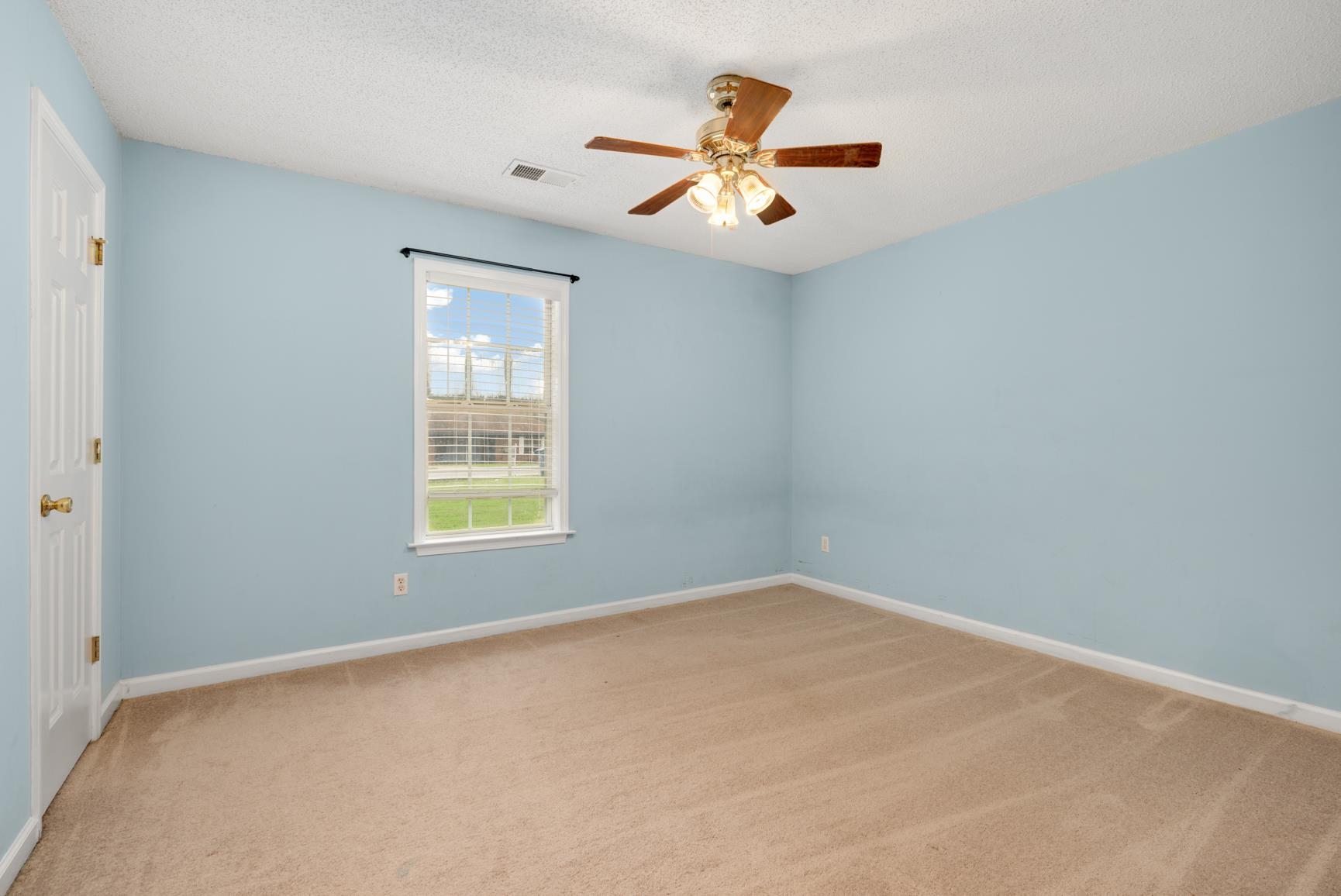 Unfurnished room featuring carpet floors, a textured ceiling, and ceiling fan