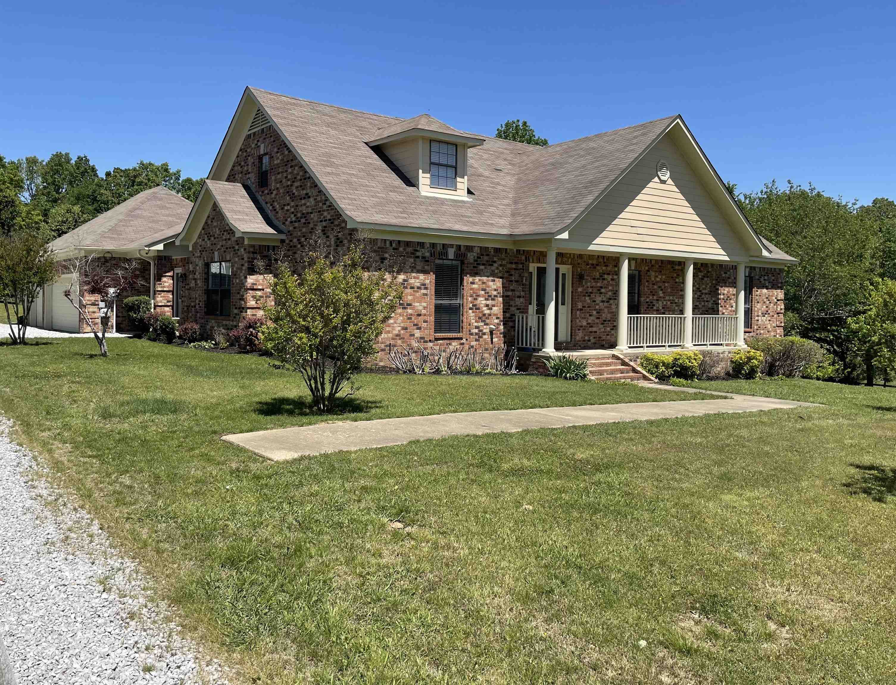 View of front of home with a porch and a front yard