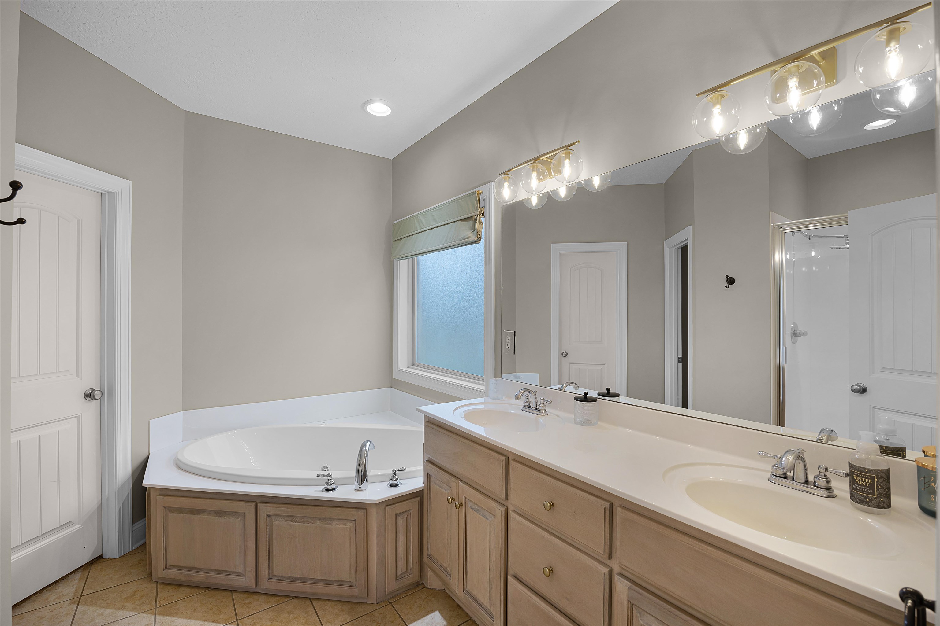 Bathroom featuring independent shower and bath, dual vanity, and tile patterned flooring