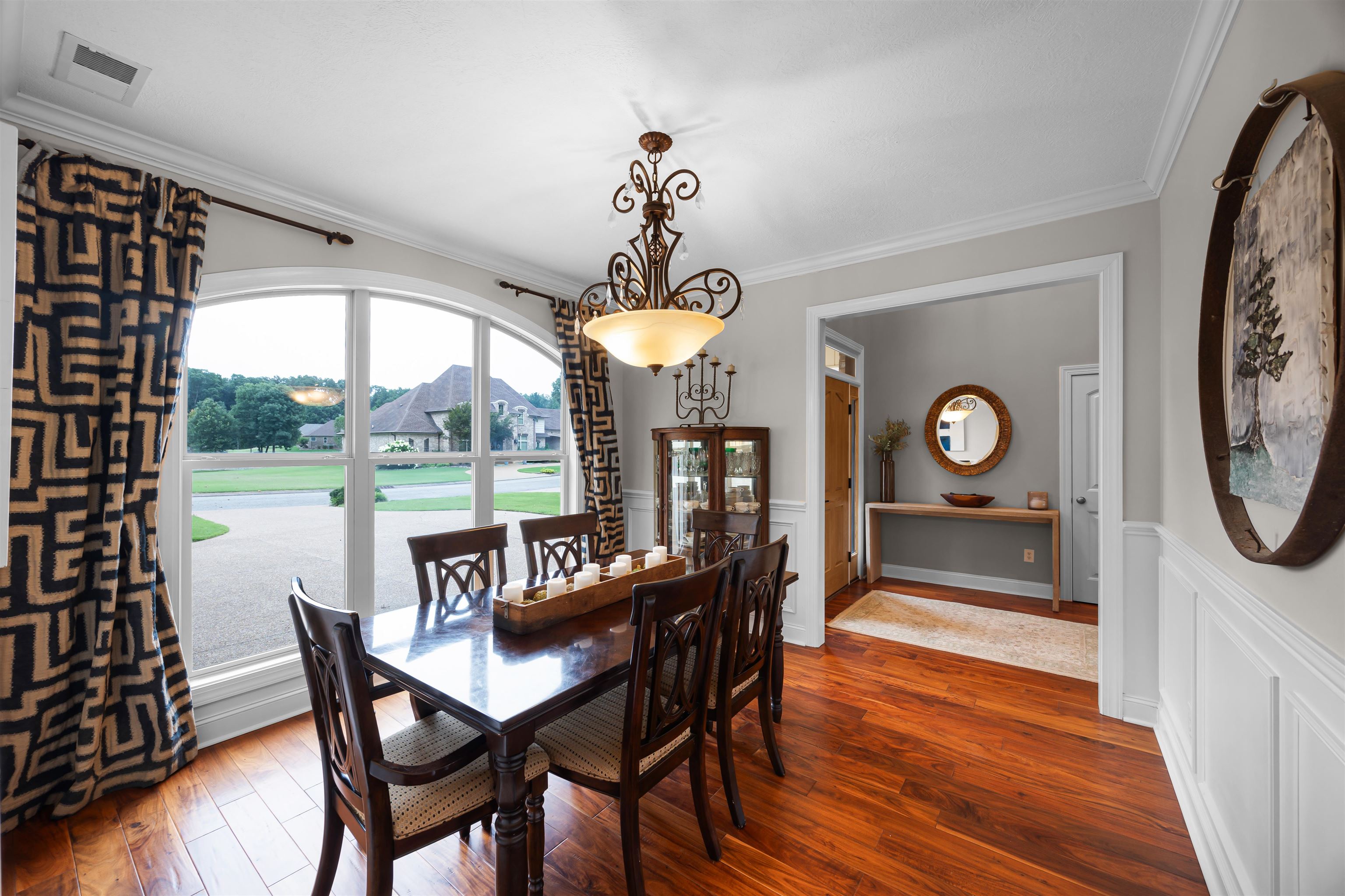 Dining space with ornamental molding and hardwood / wood-style flooring