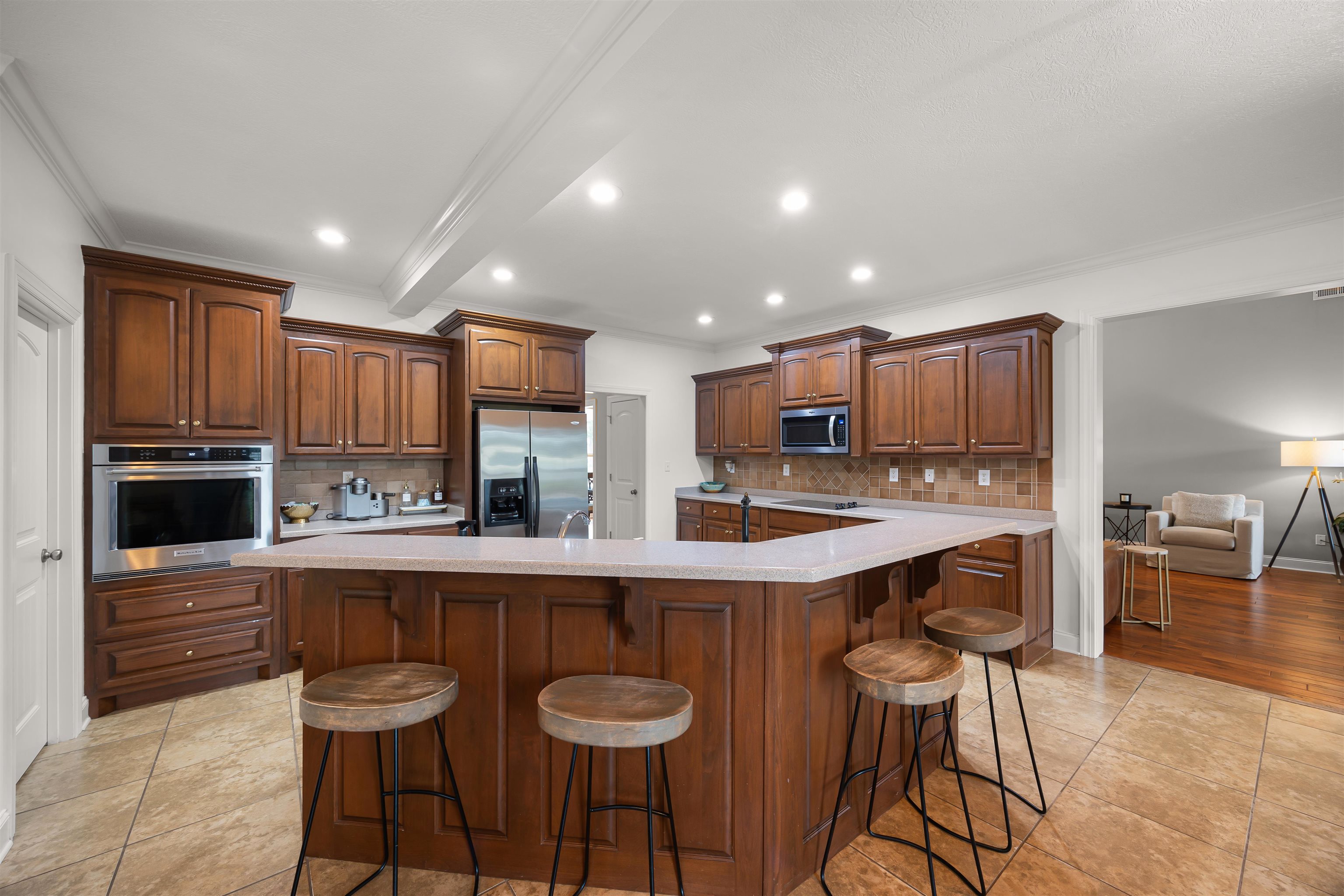 Kitchen featuring stainless steel appliances, a breakfast bar, light hardwood / wood-style floors, decorative backsplash, and crown molding