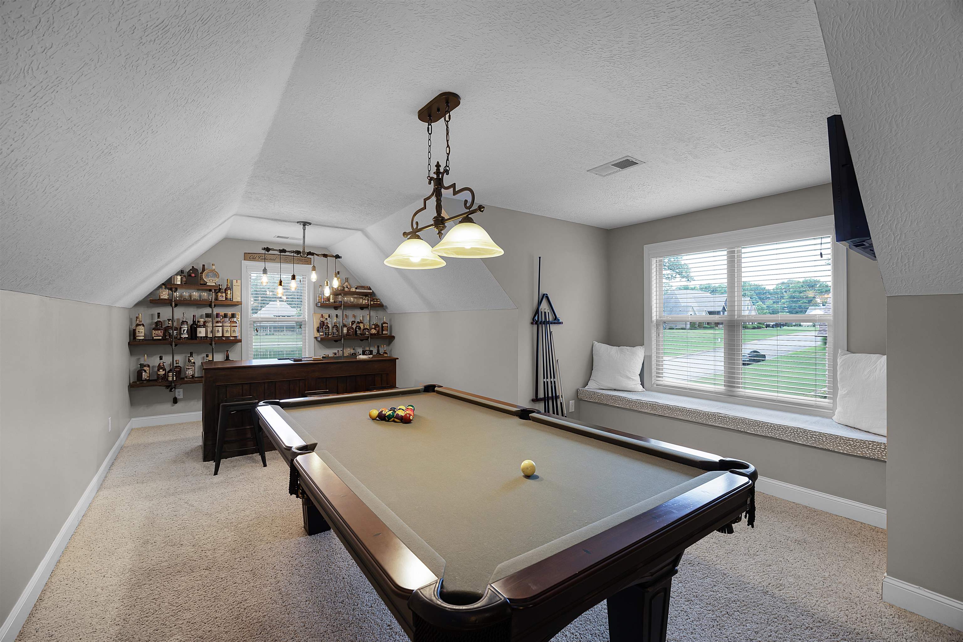 Playroom featuring vaulted ceiling, light colored carpet, billiards, and a textured ceiling