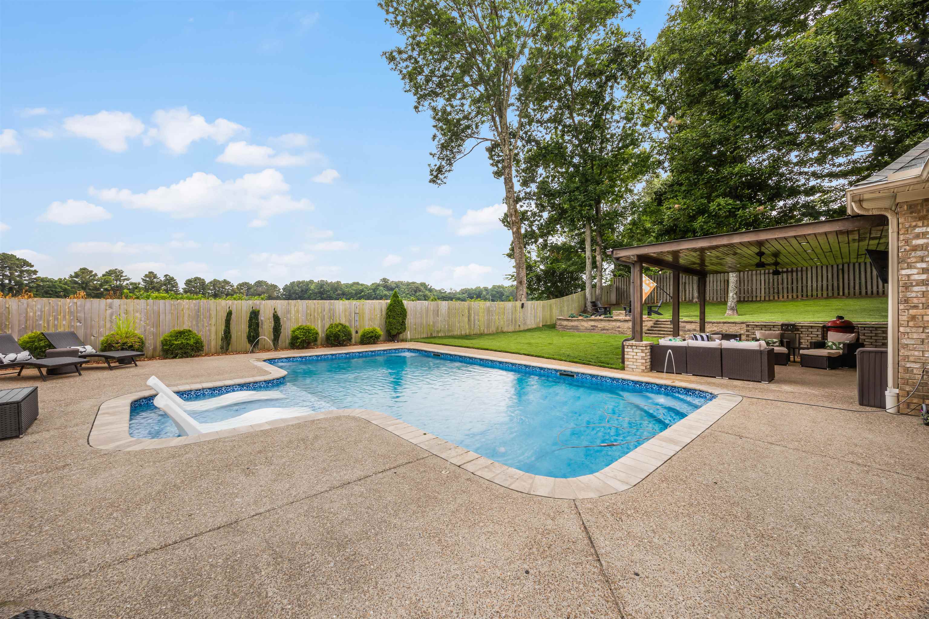 View of pool featuring a lawn, a patio, a hot tub, and an outdoor living space
