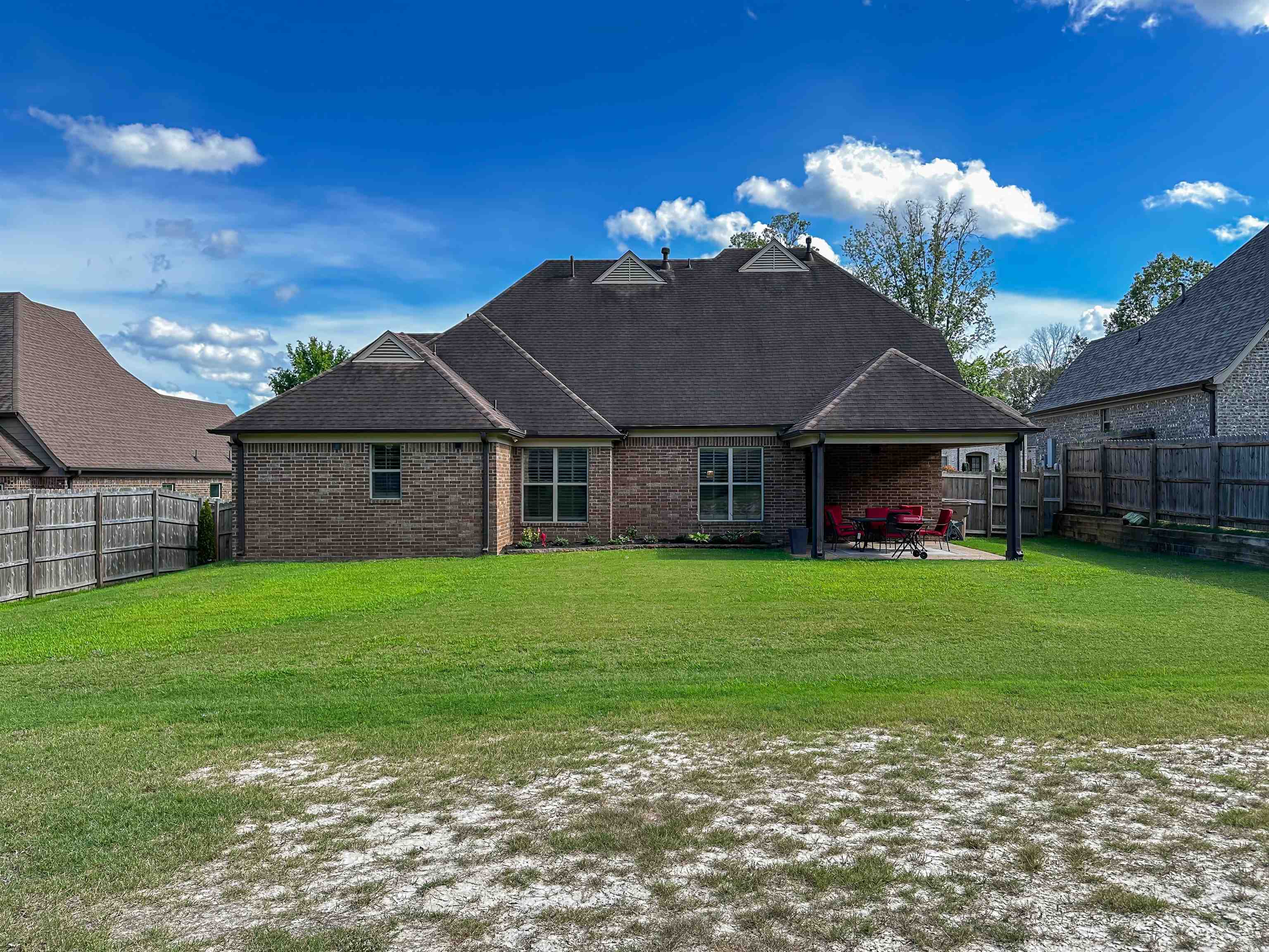 Back of house with a patio and a yard