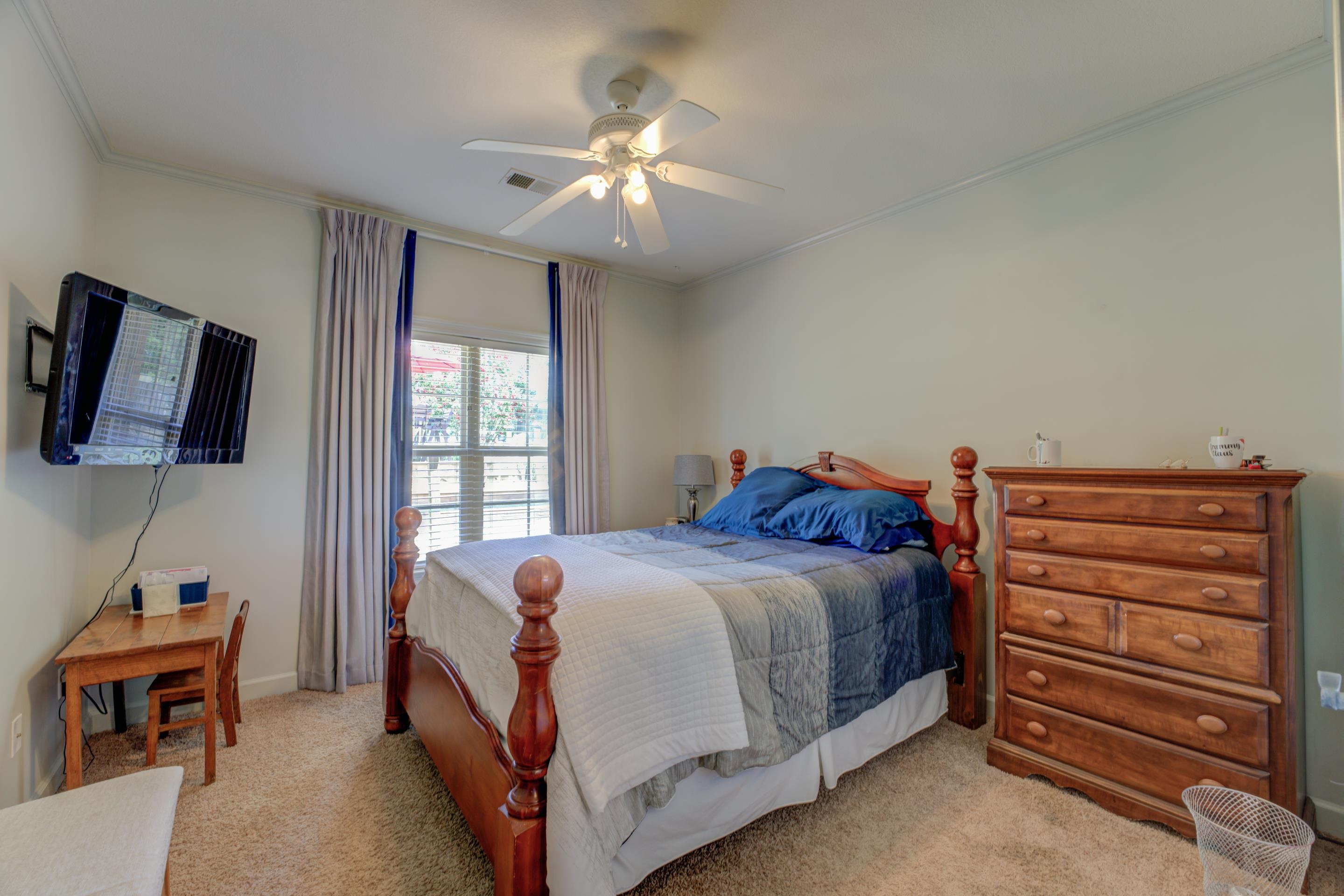 Sleep tight in the second bedroom with ceiling fan, soft carpeting, closet, and neutral colors.