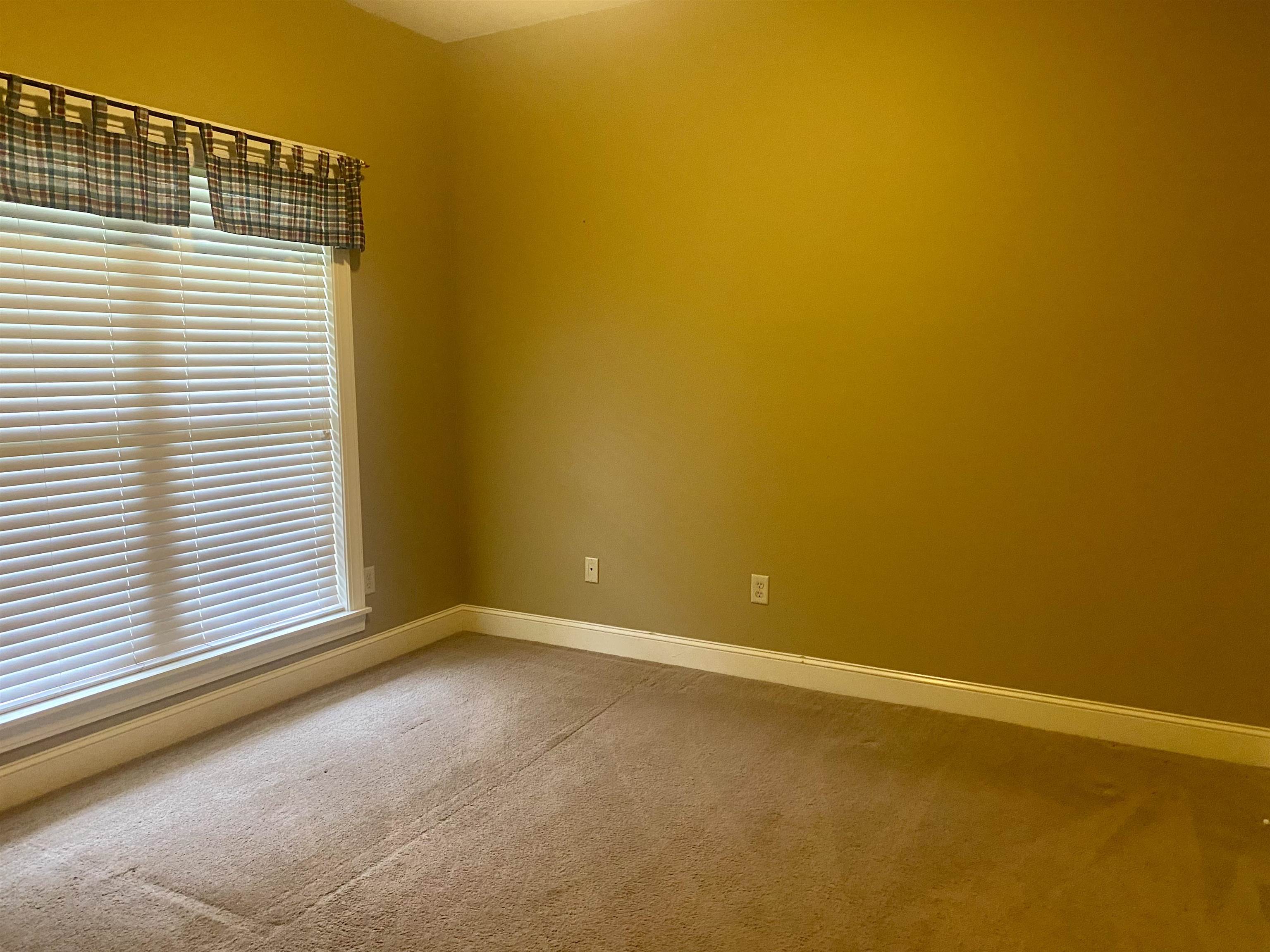 Bedroom with carpet floors and a healthy amount of sunlight