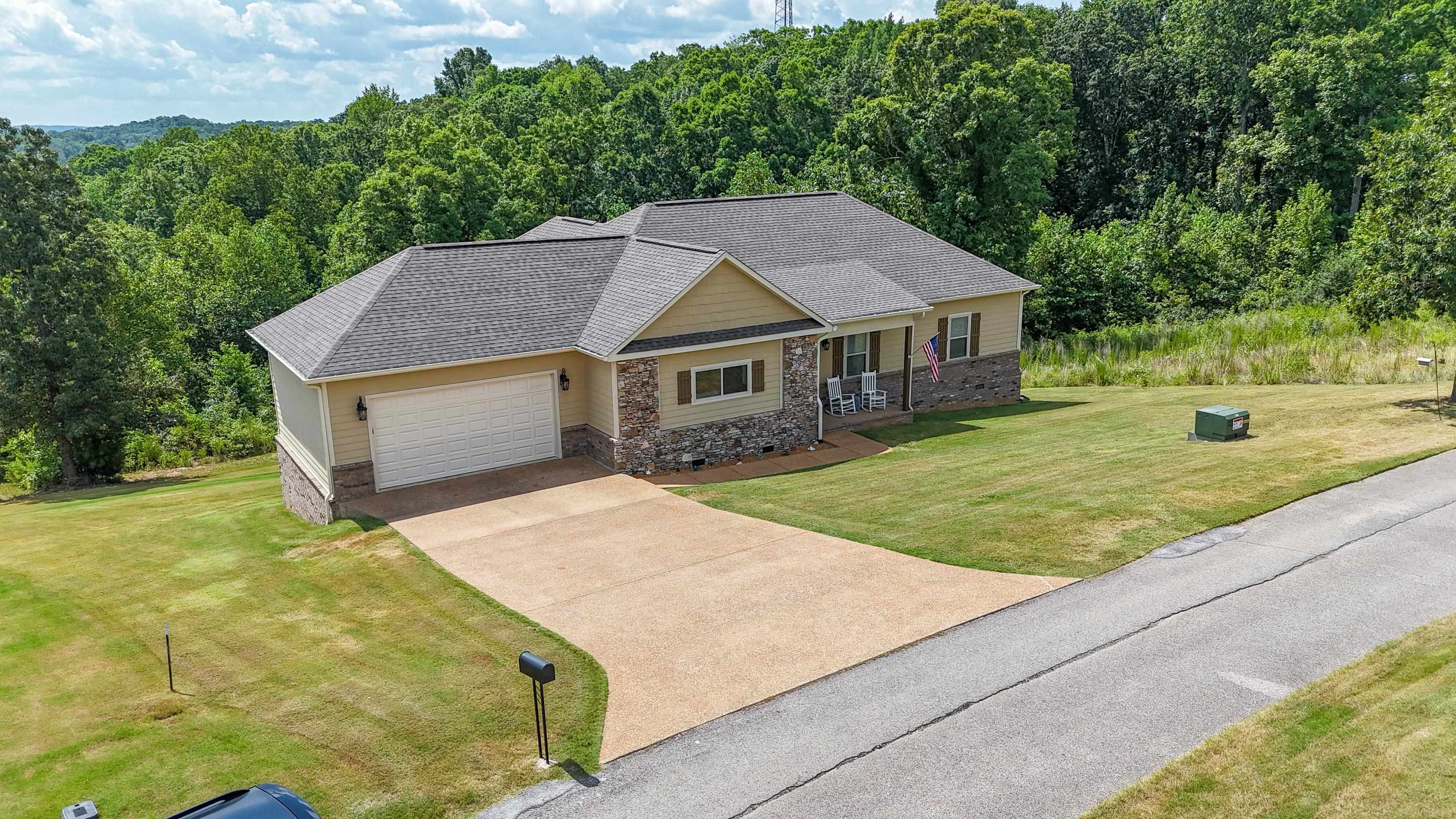 Craftsman-style house featuring a porch, a garage, and a front yard