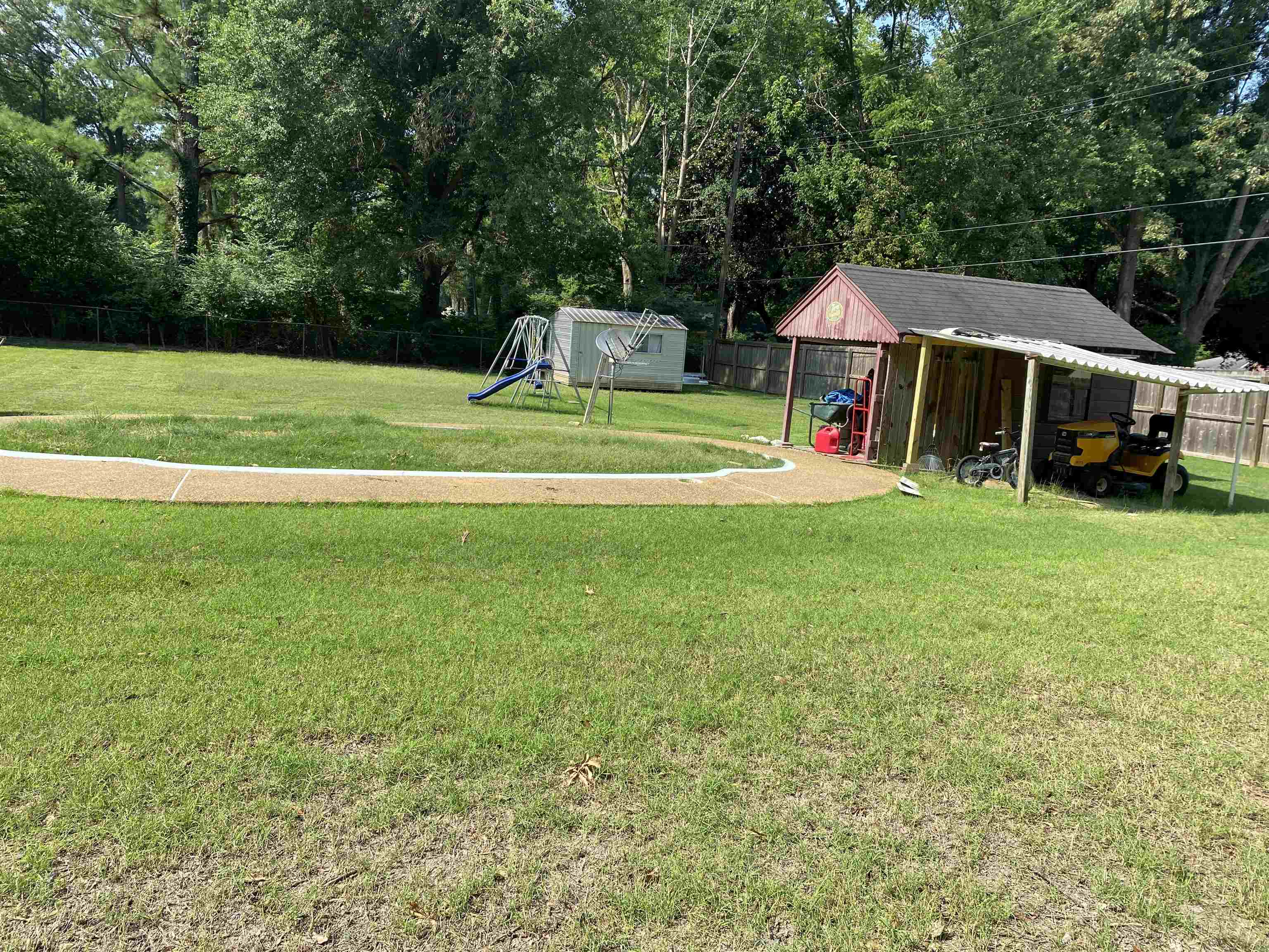 View of yard featuring a playground and a storage shed