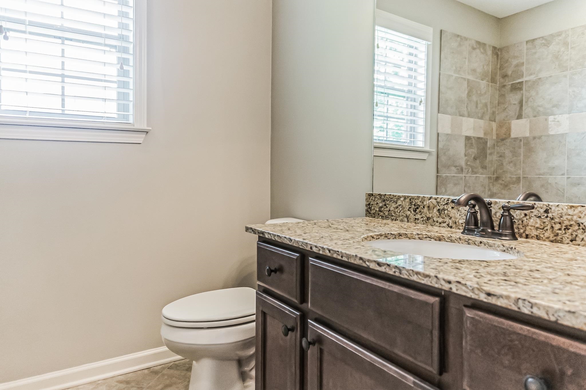 Bathroom with tile patterned flooring, toilet, and vanity