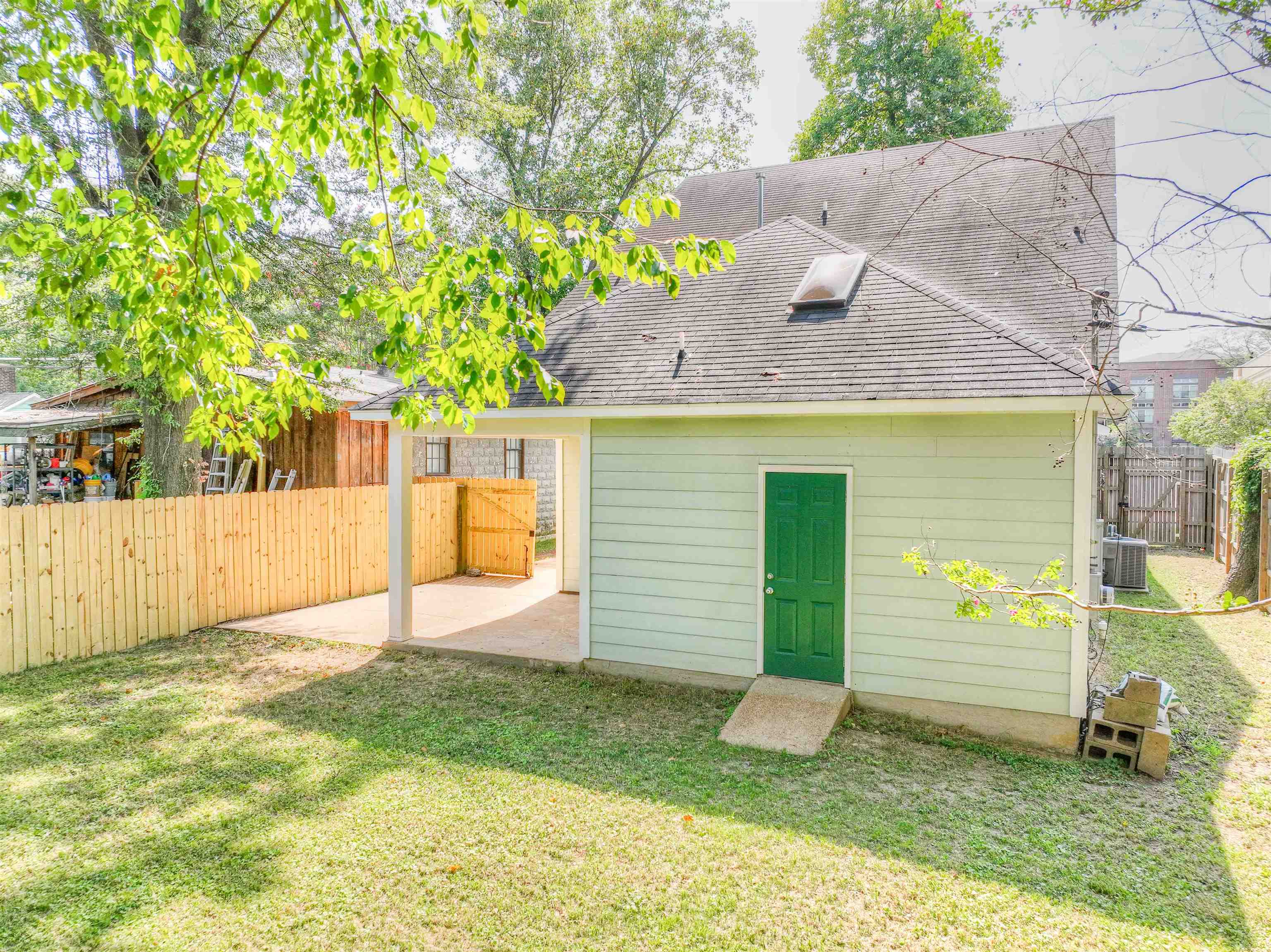 Back of property with central AC and a lawn