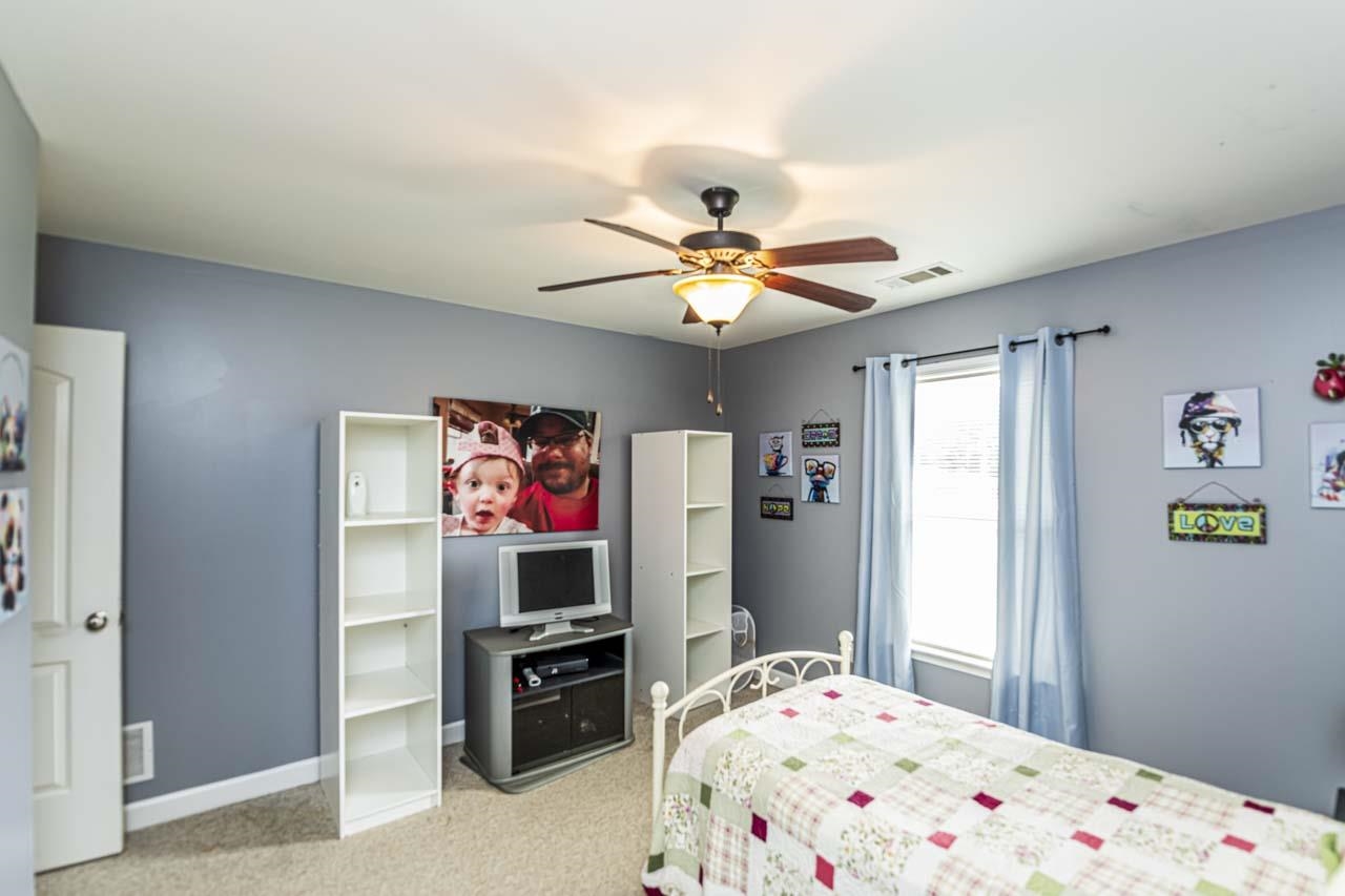 Bedroom with light carpet and ceiling fan