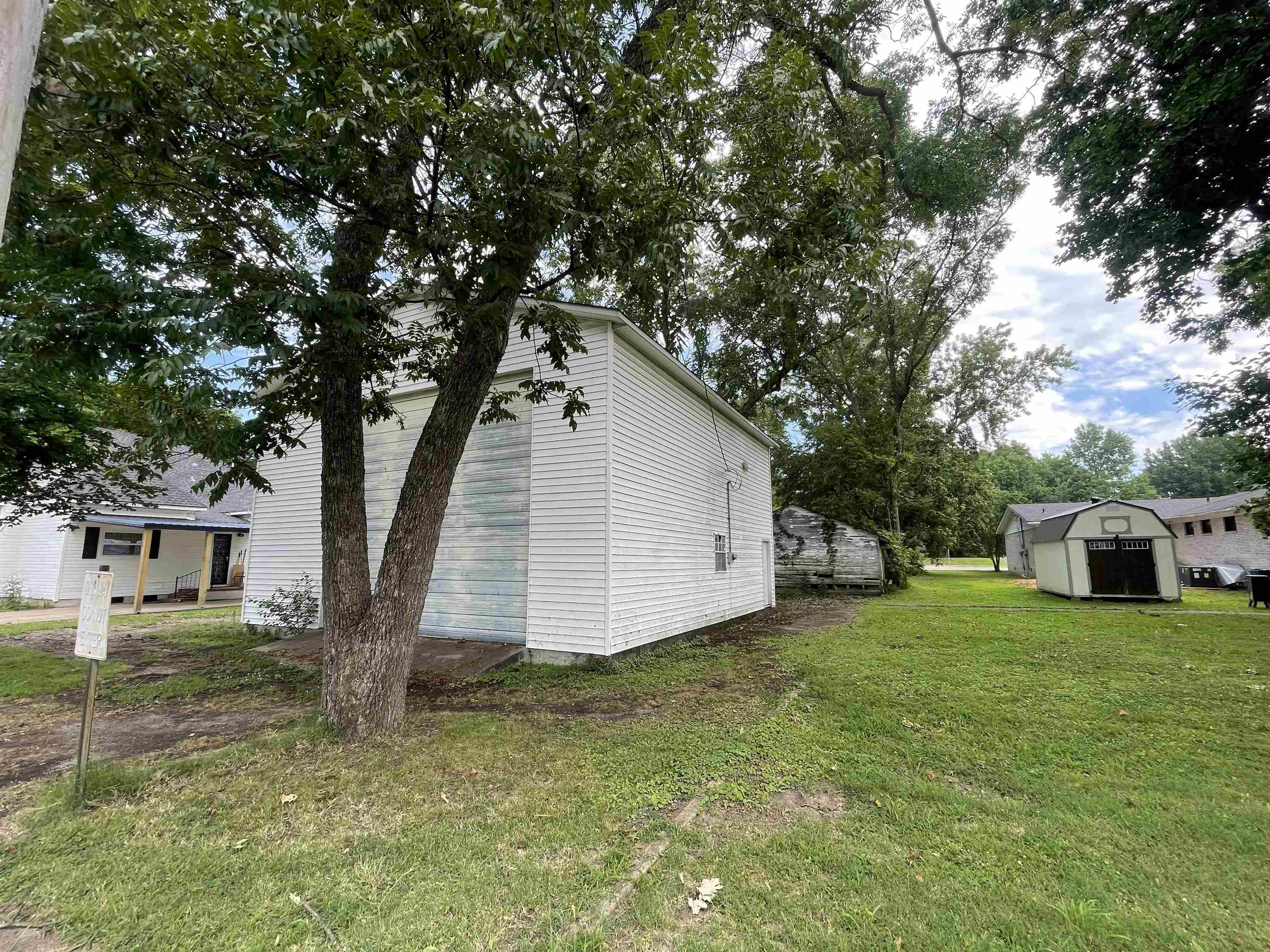View of side of property with an outbuilding and a lawn