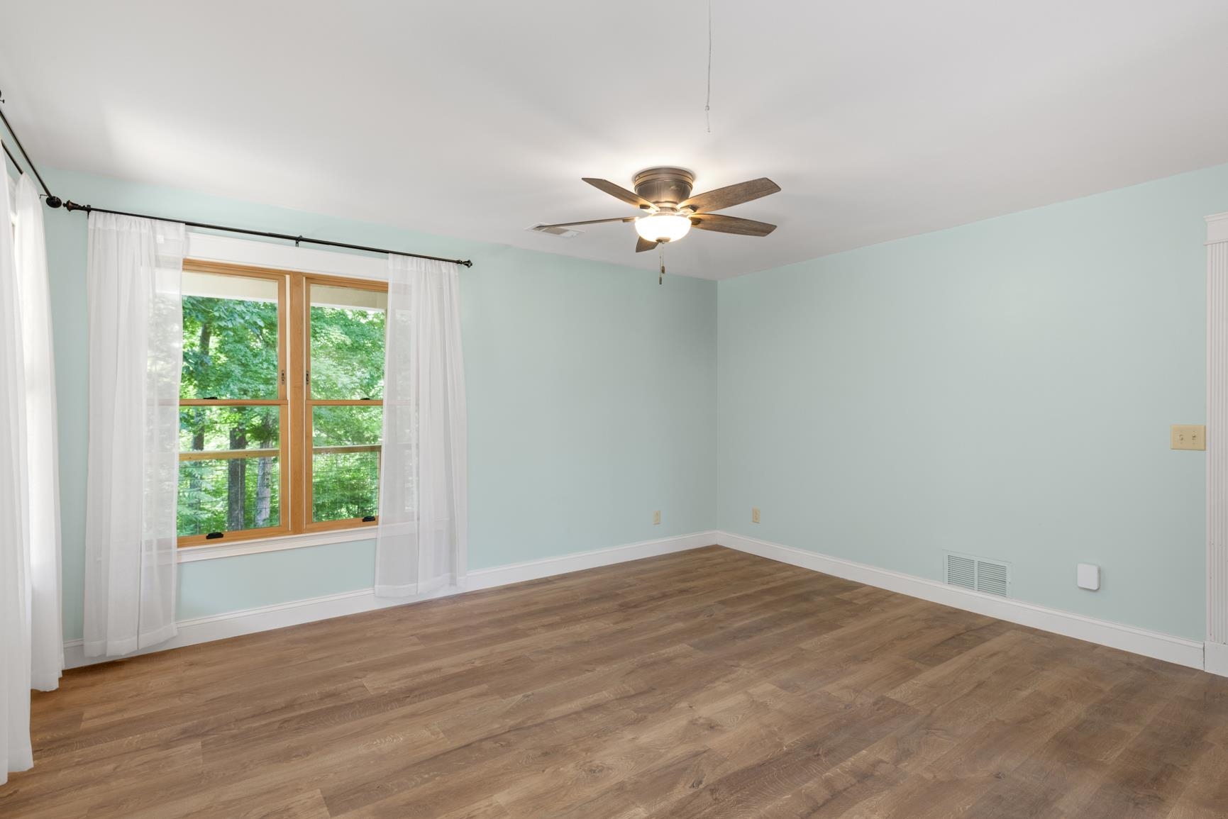 Primary bedroom featuring ceiling fan and hardwood / wood-style flooring