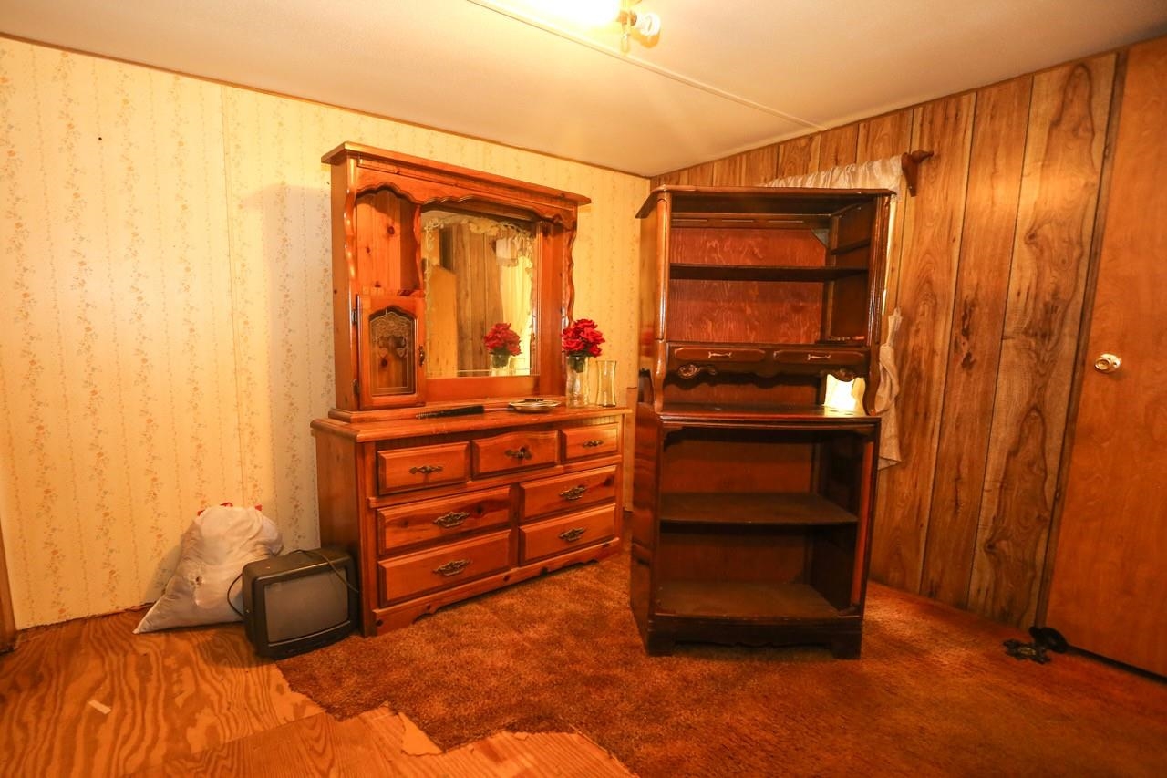 Interior space featuring wood walls, carpet floors, and lofted ceiling