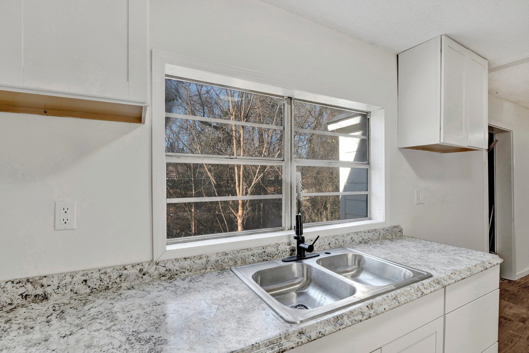 Kitchen featuring sink, white cabinets, and dark hardwood / wood-style floors