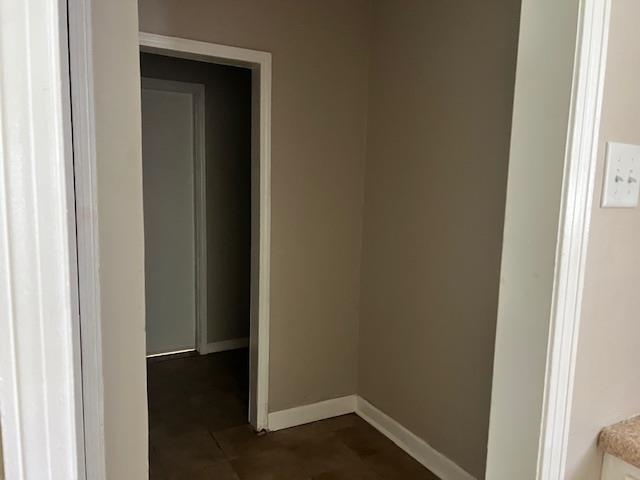 Corridor featuring dark tile patterned floors