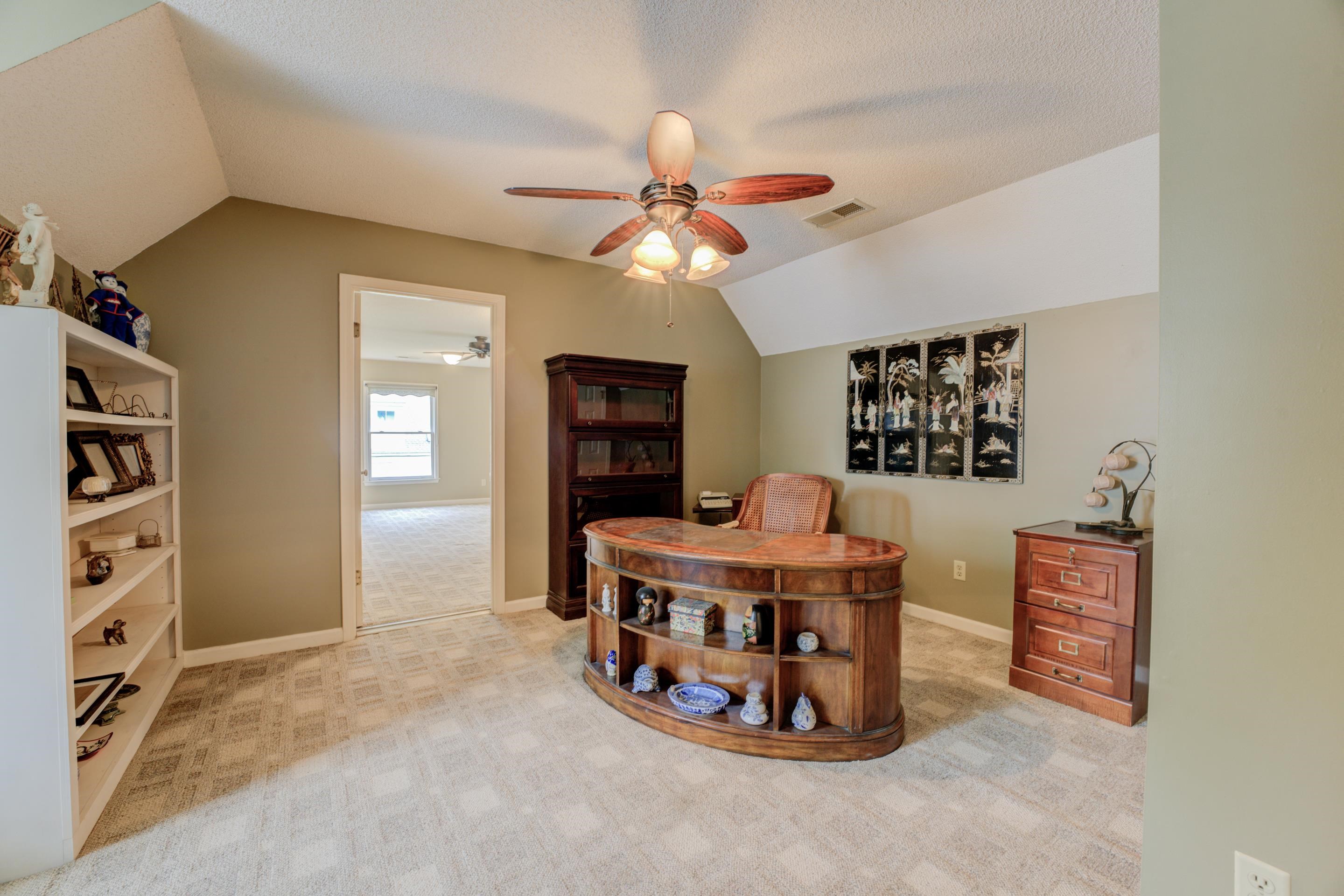 Dining space with light carpet, ceiling fan, vaulted ceiling, and a textured ceiling