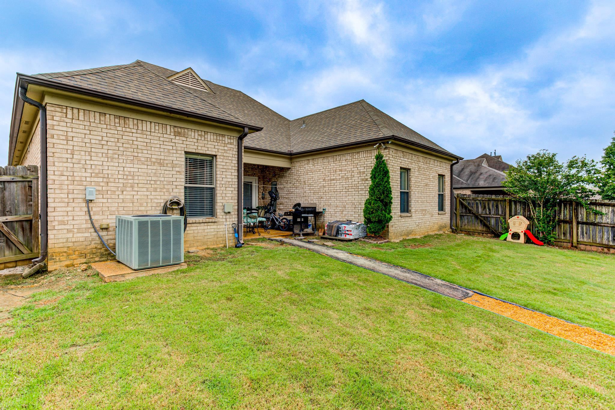 Back of house featuring a lawn and central AC unit