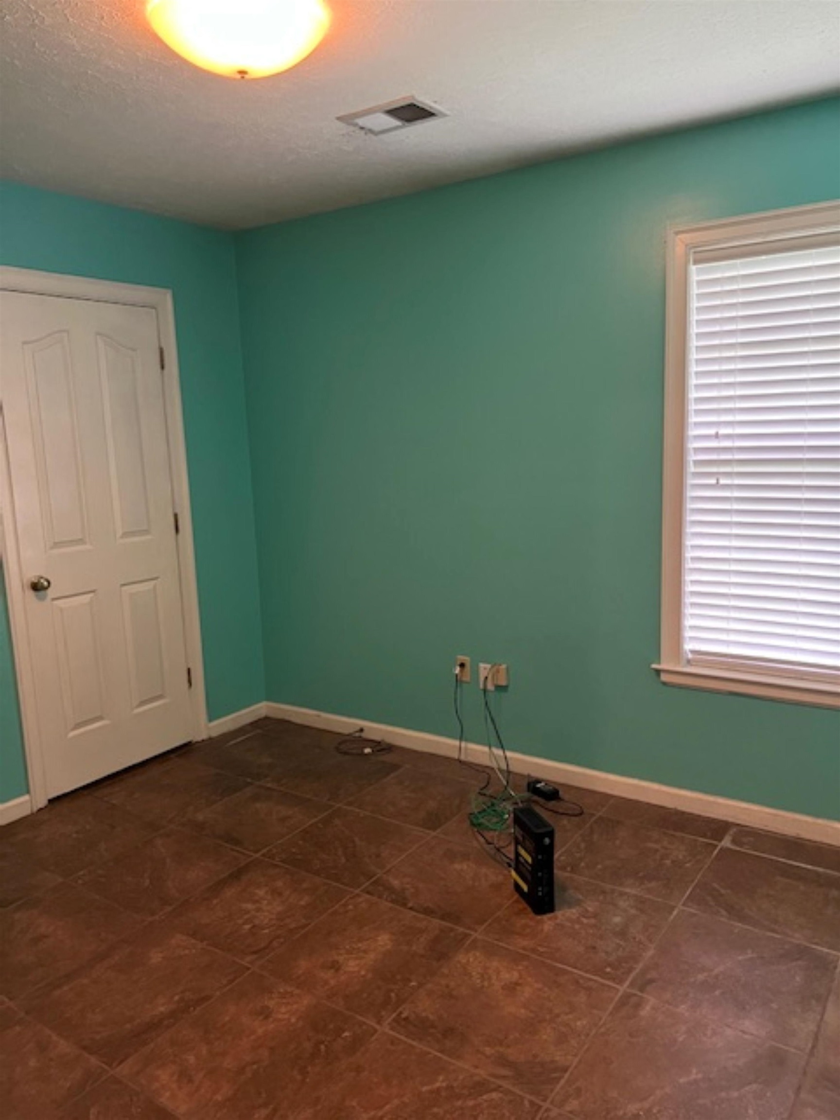 Empty room featuring dark tile patterned flooring