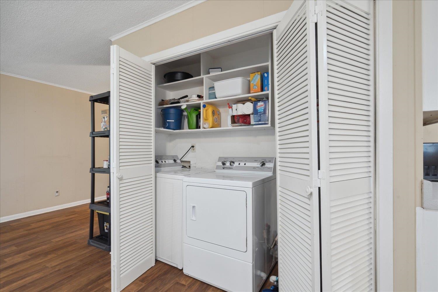 Washroom featuring crown molding, independent washer and dryer, dark hardwood / wood-style flooring, and a textured ceiling