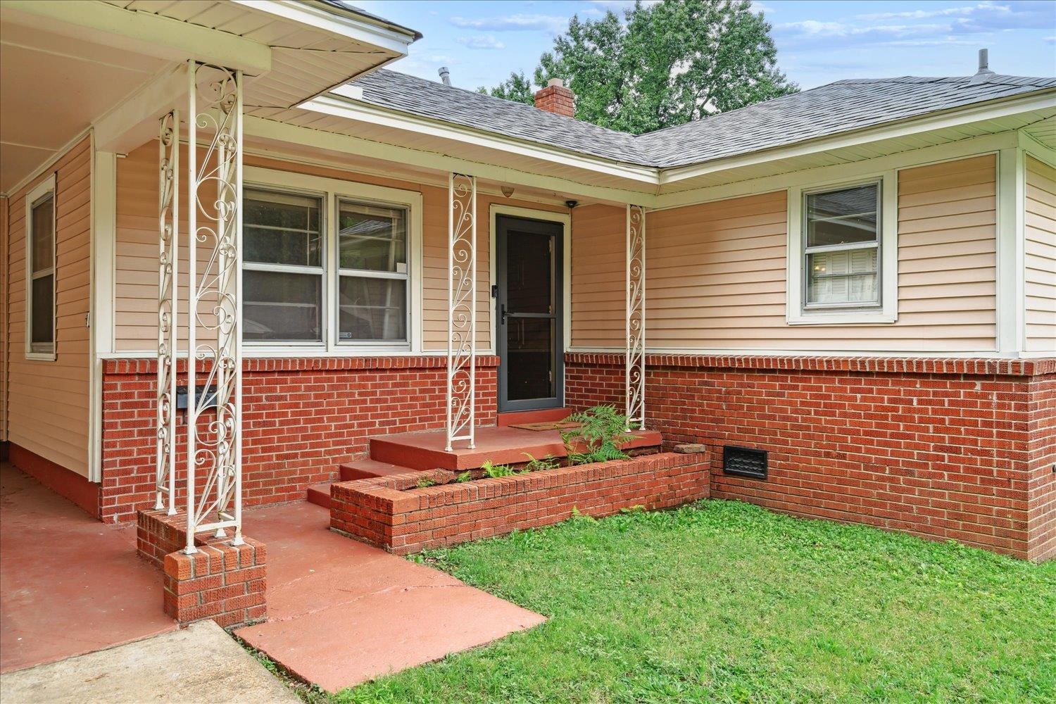 Doorway to property with a lawn