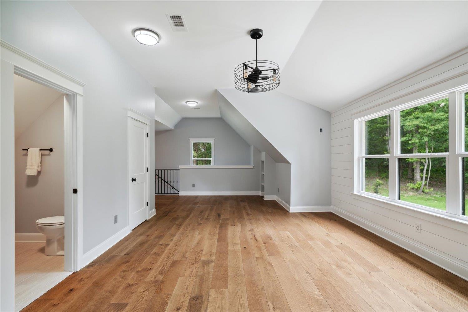 Additional living space featuring a wealth of natural light, lofted ceiling, and light wood-type flooring