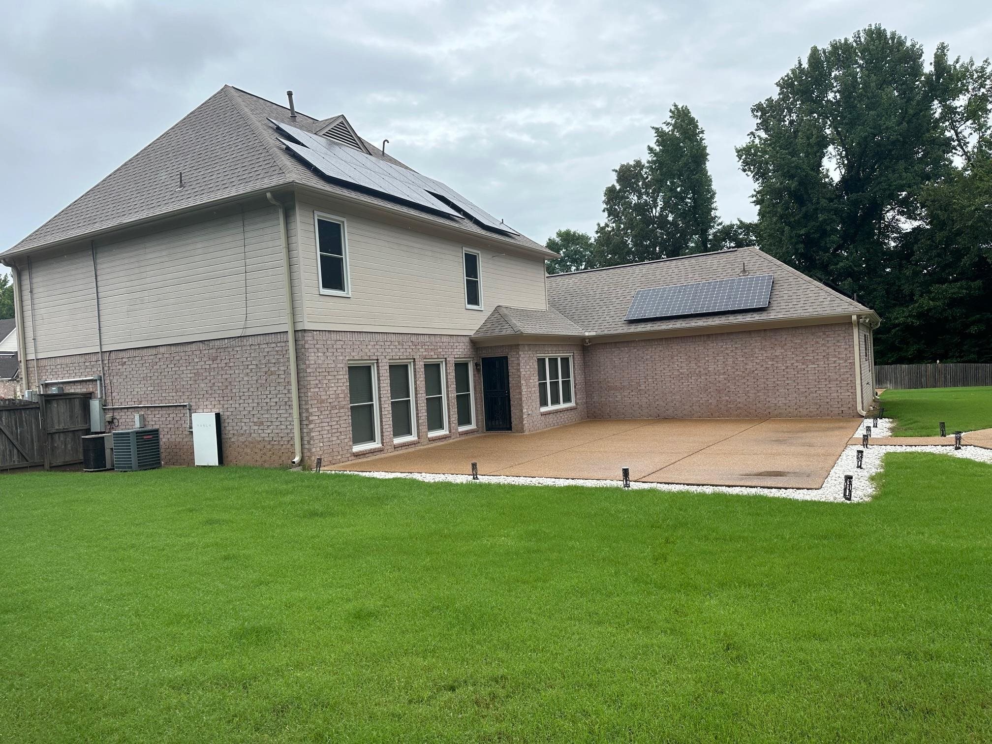 Rear view of property with cooling unit, a patio, a yard, and solar panels