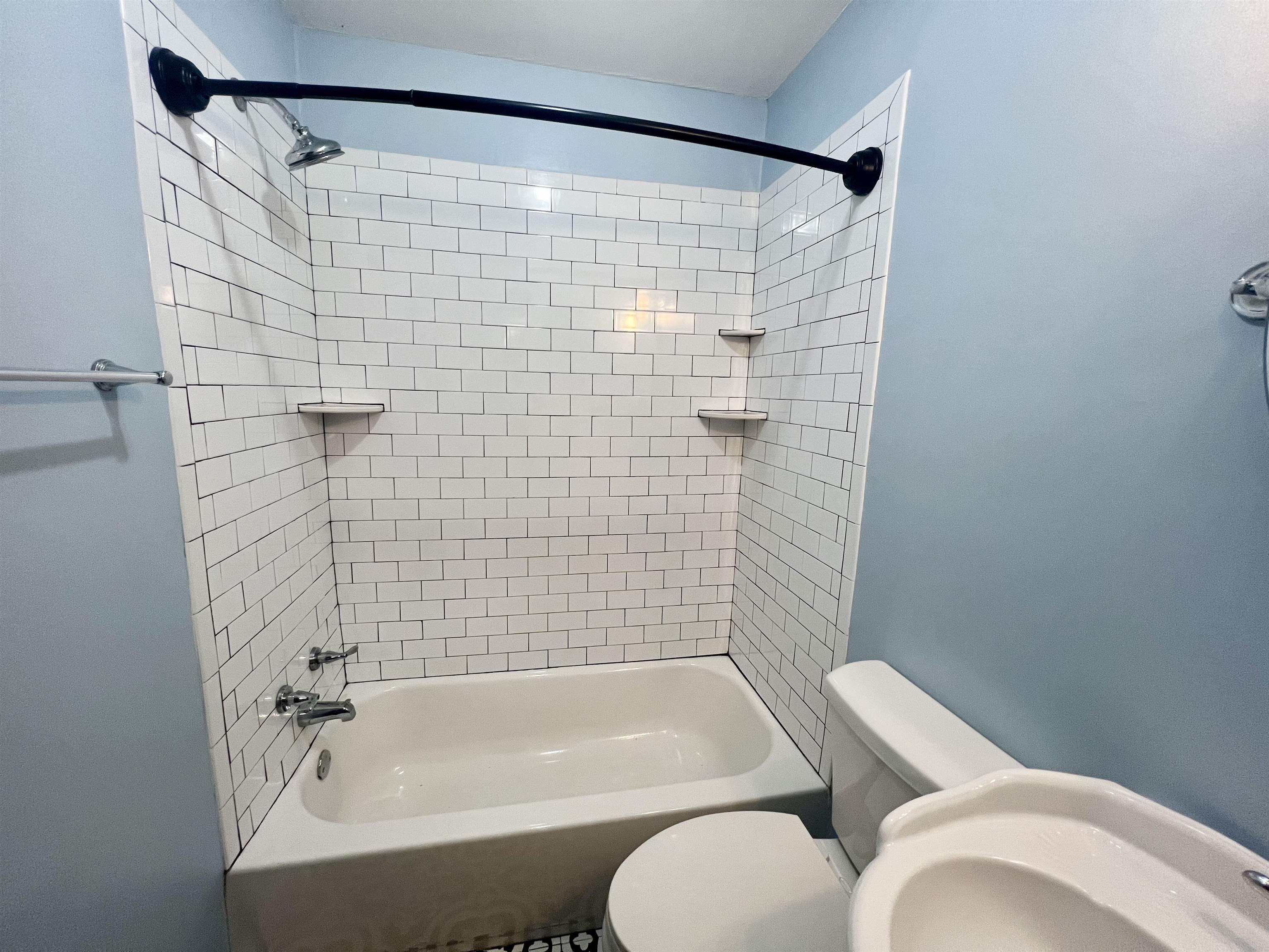 Bathroom with toilet and tiled shower / bath