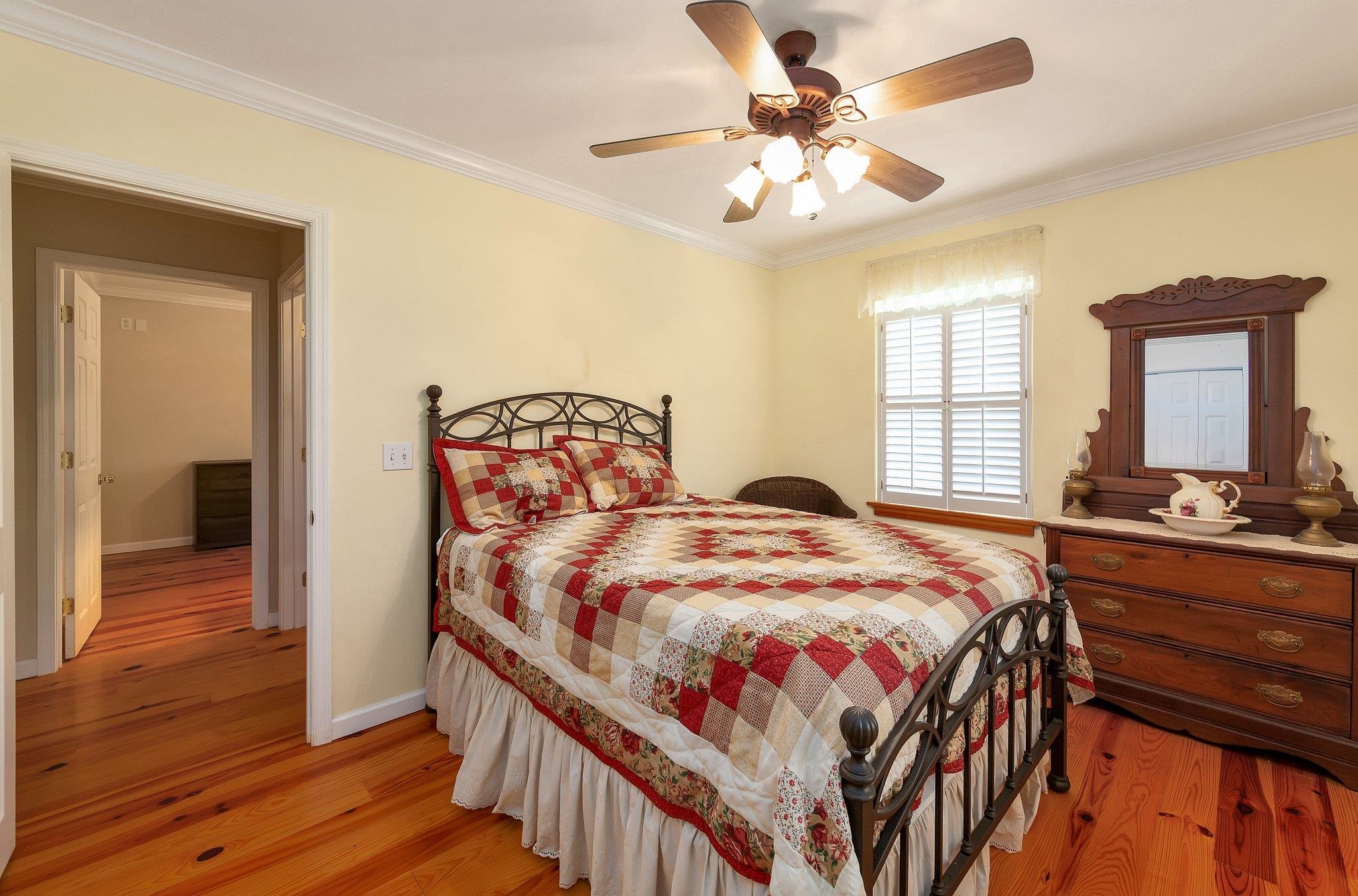 Bedroom featuring ornamental molding, light wood-type flooring, and ceiling fan