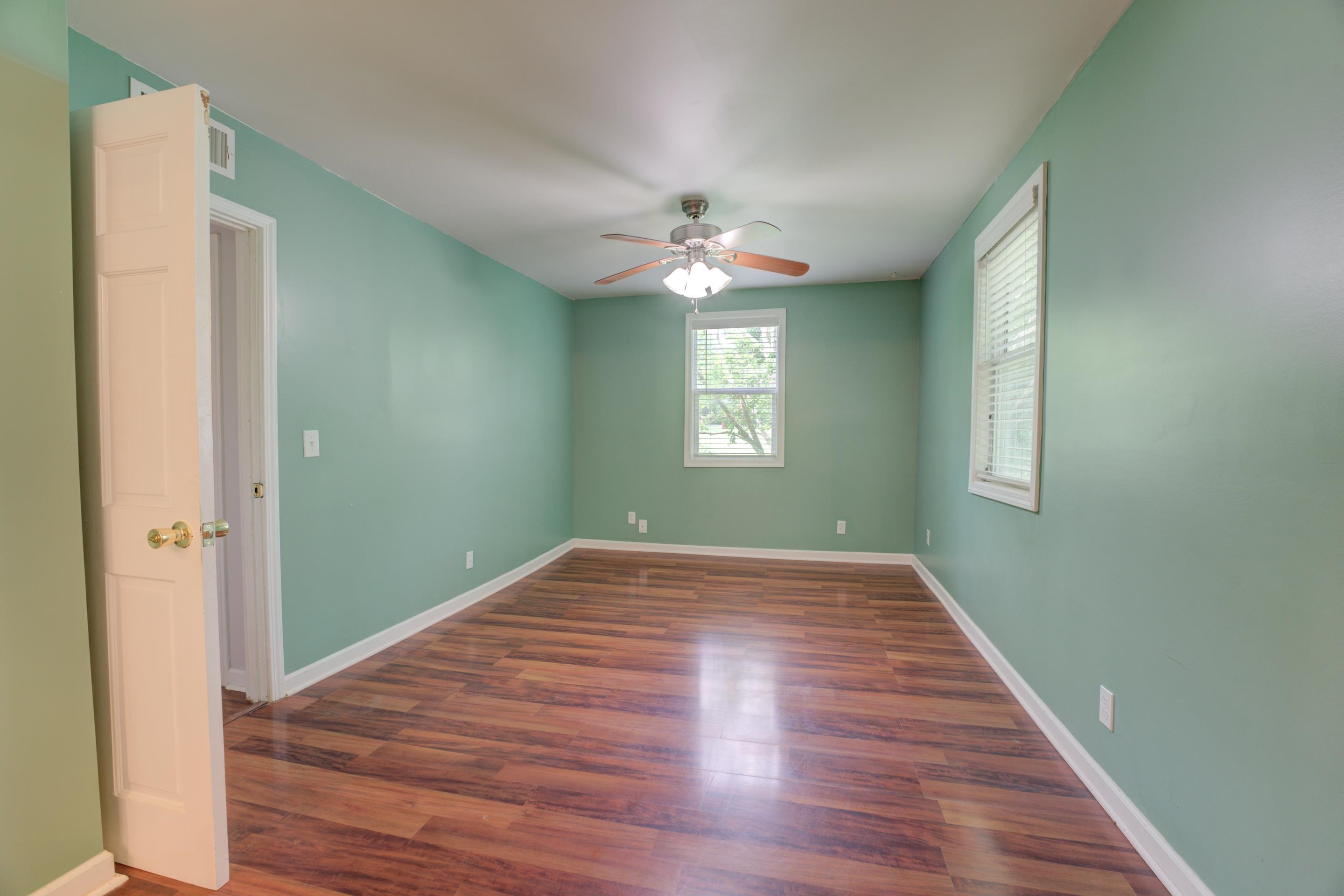 Empty room featuring hardwood / wood-style flooring and ceiling fan