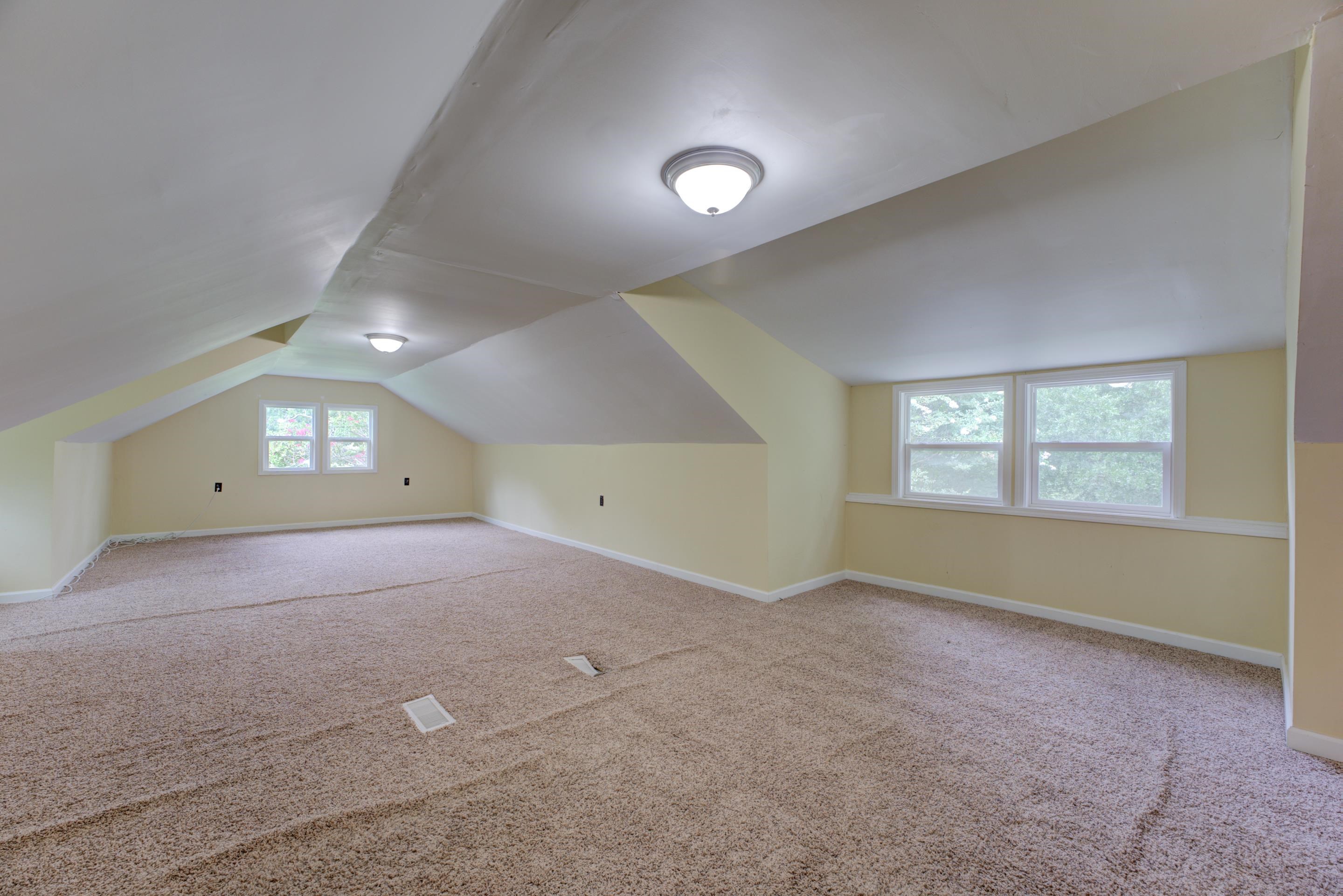 Bonus room featuring lofted ceiling and carpet flooring