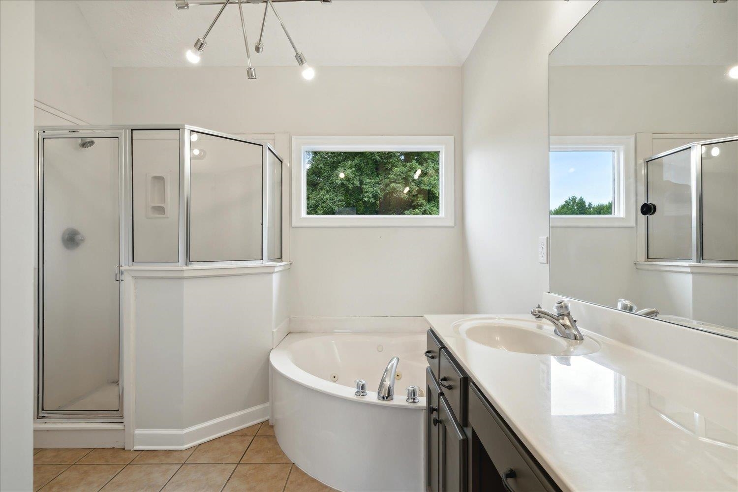 Bathroom with tile patterned floors, vanity, and separate shower and tub