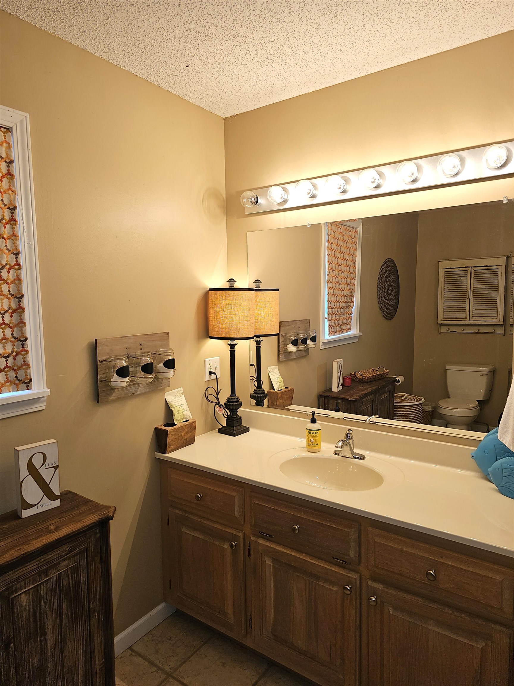 Bathroom featuring vanity, toilet, a textured ceiling, and tile patterned flooring