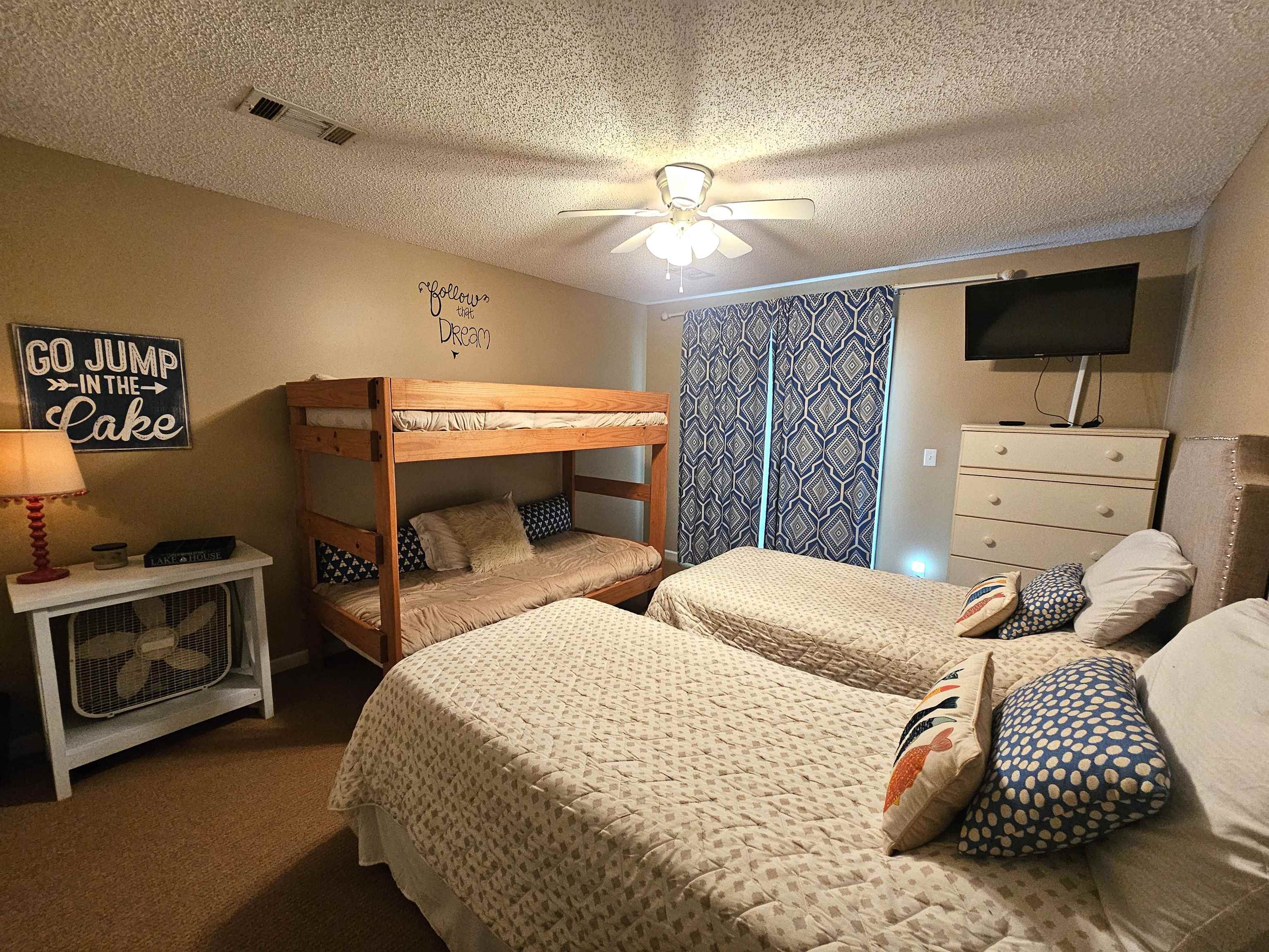 Bedroom with dark colored carpet, a textured ceiling, and ceiling fan