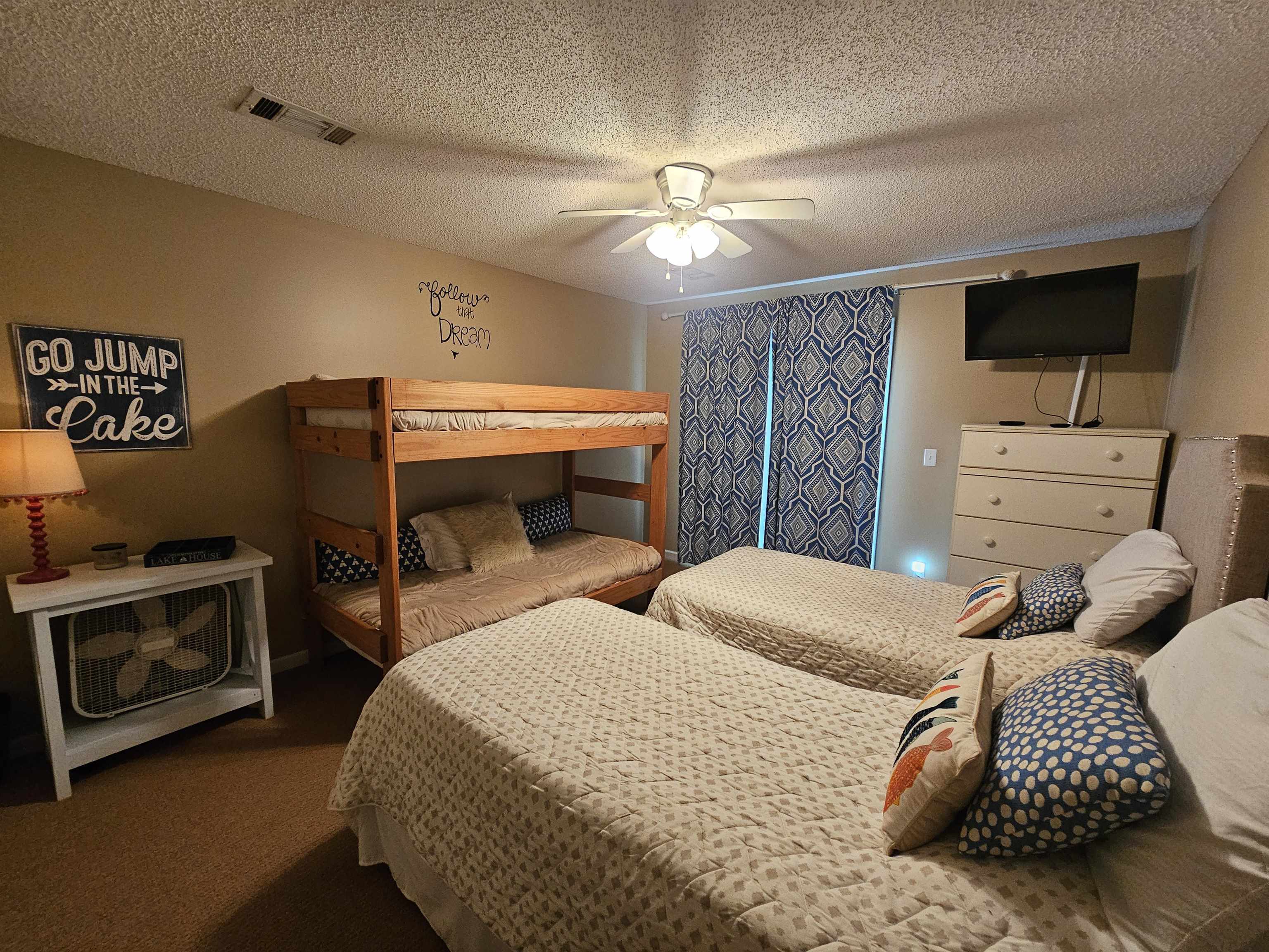 Carpeted bedroom featuring a textured ceiling and ceiling fan