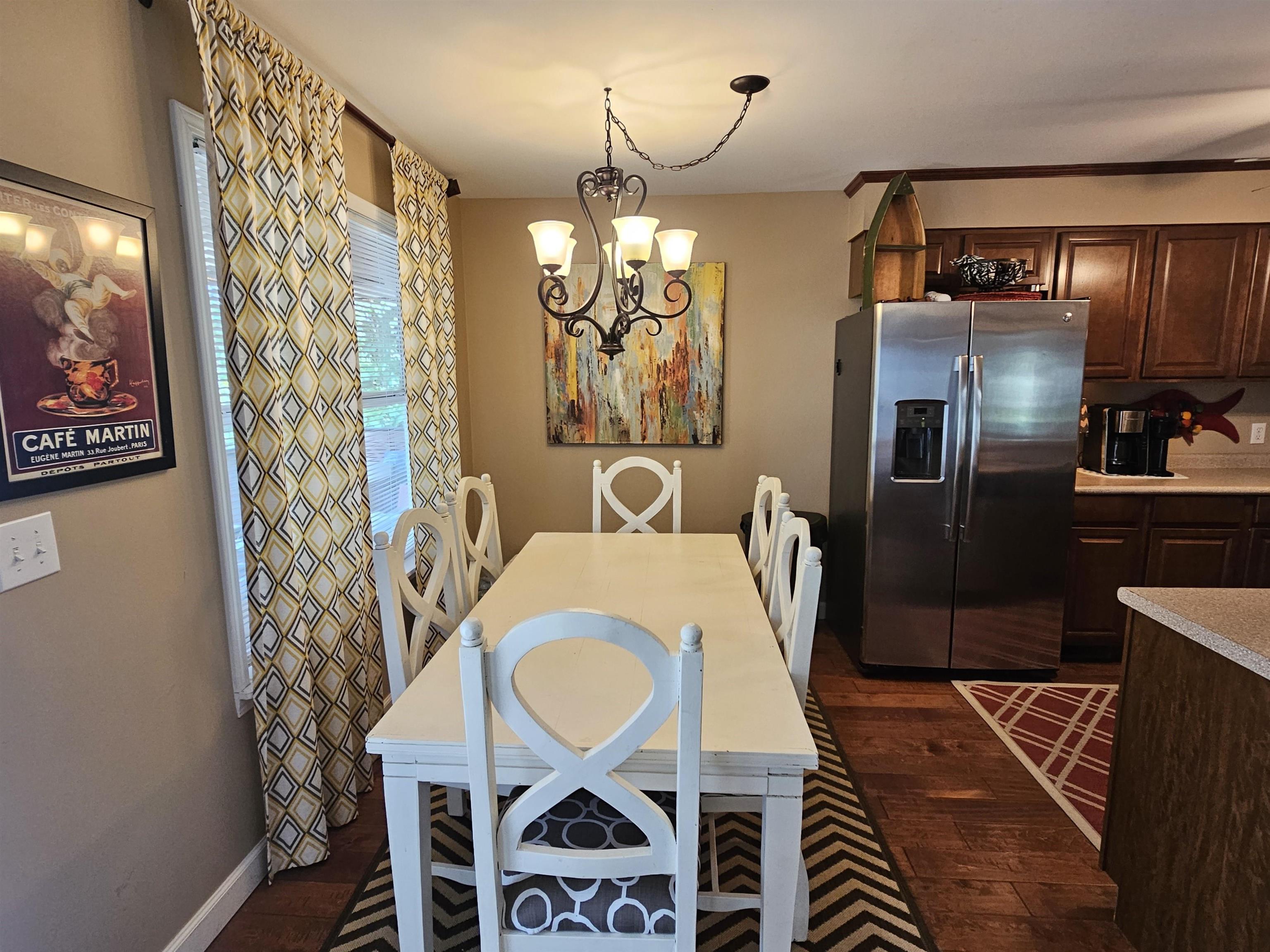 Dining space with dark hardwood / wood-style floors and an inviting chandelier