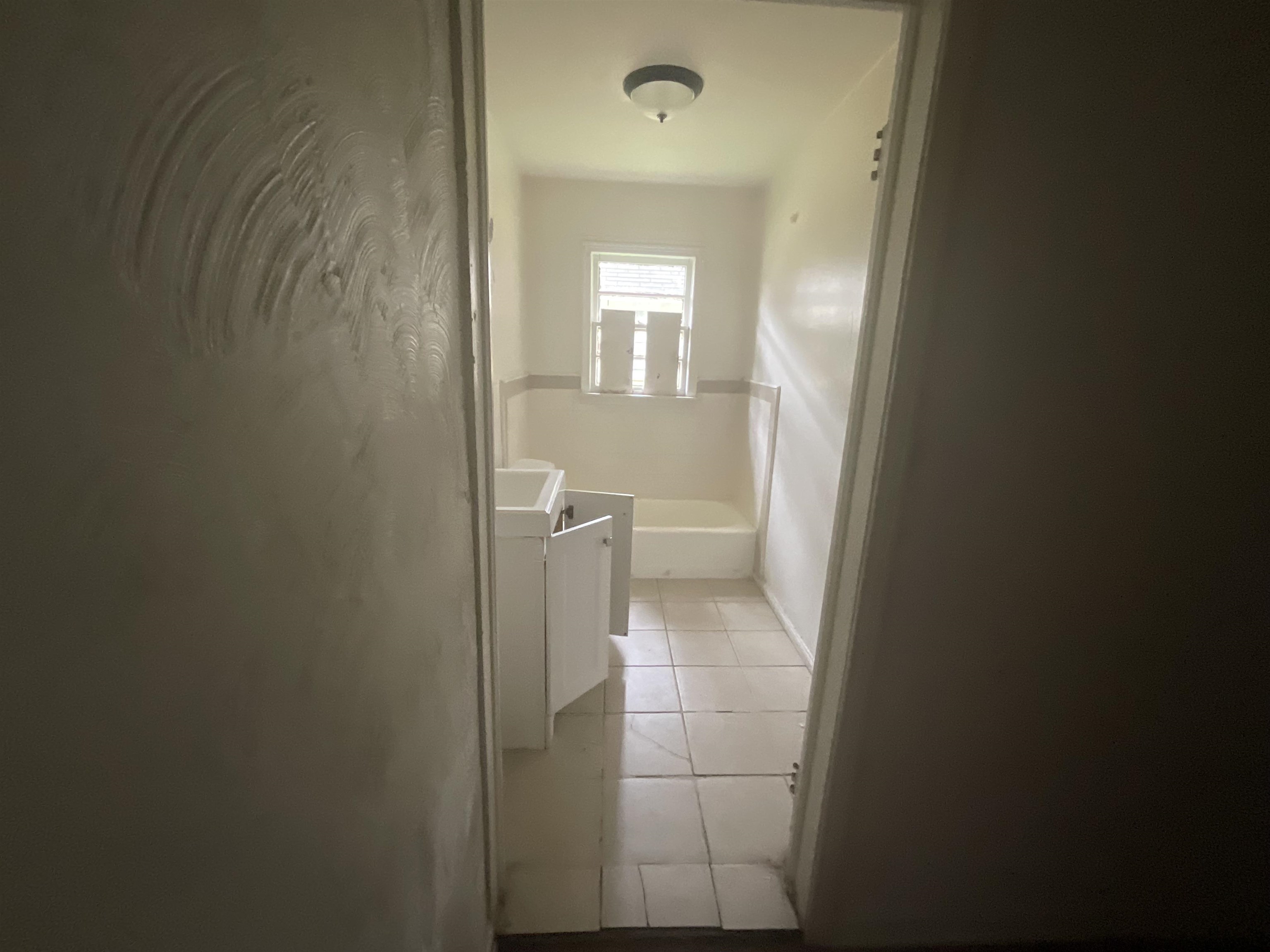 Hall featuring light tile patterned floors