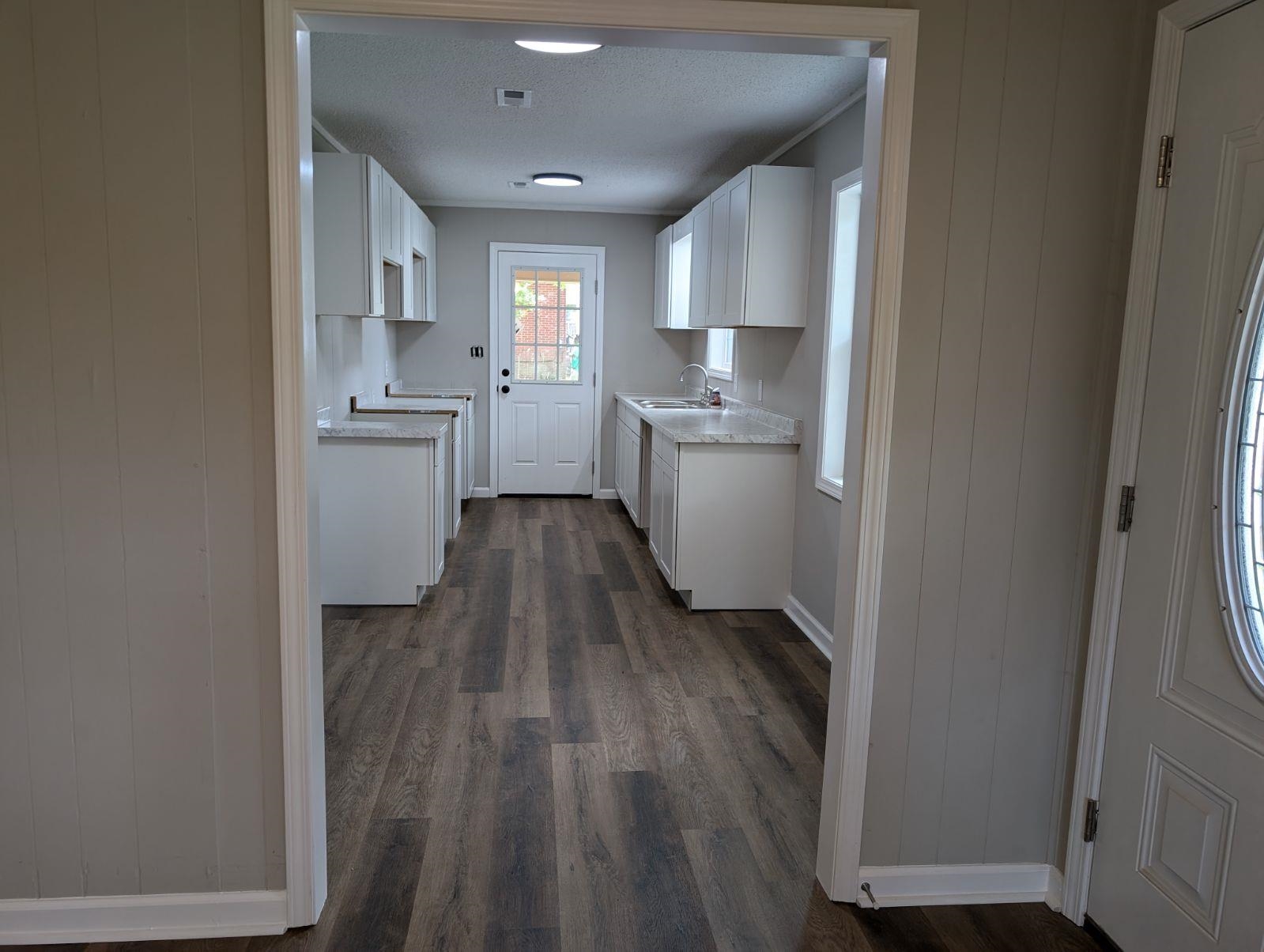 Kitchen featuring white cabinetry, dark hardwood / wood-style flooring, sink, and a textured ceiling