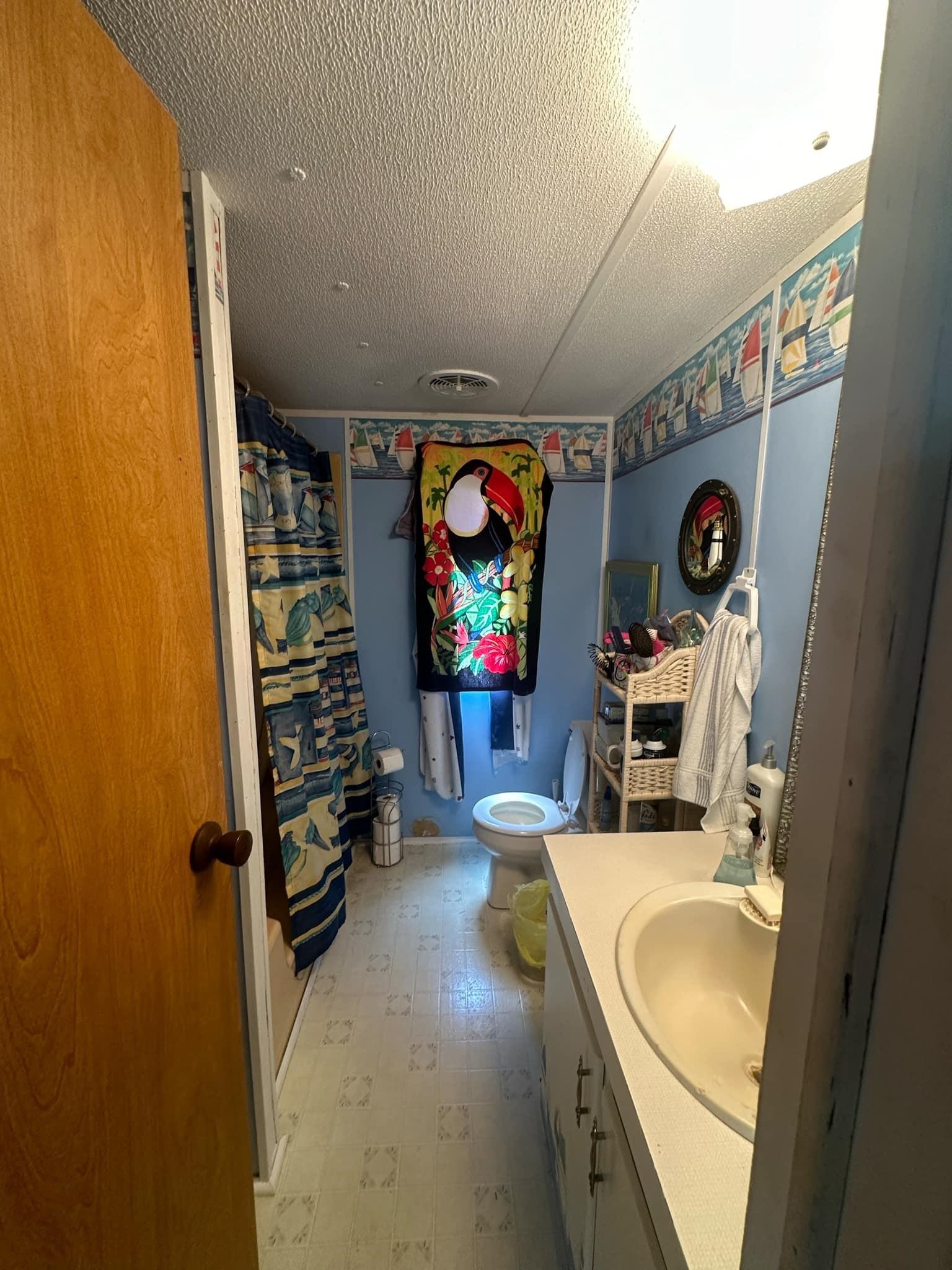 Bathroom with vanity, a textured ceiling, tile patterned flooring, and toilet