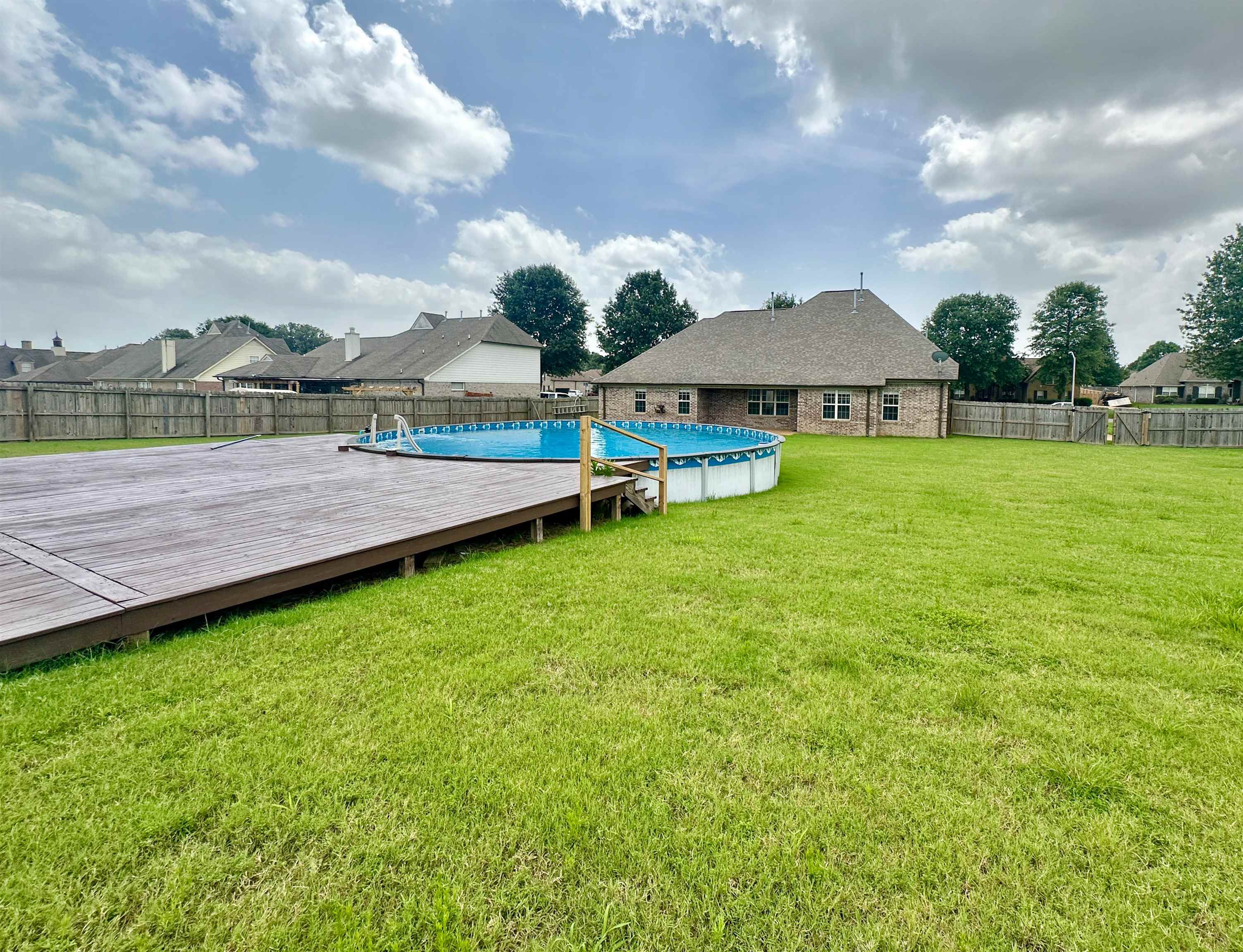 View of yard with a swimming pool side deck for Summer fun!