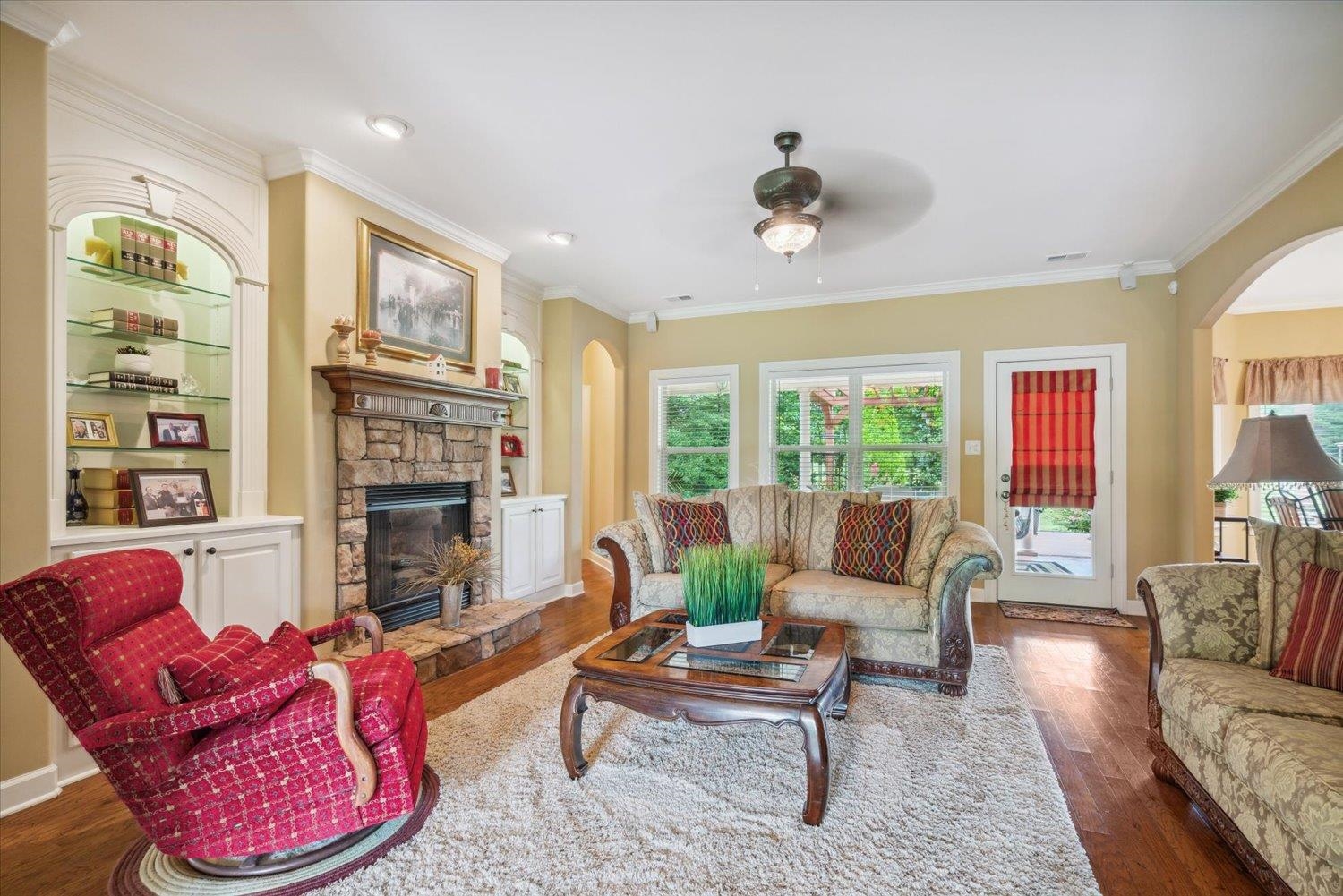 Living room with a fireplace, dark hardwood / wood-style flooring, and ornamental molding